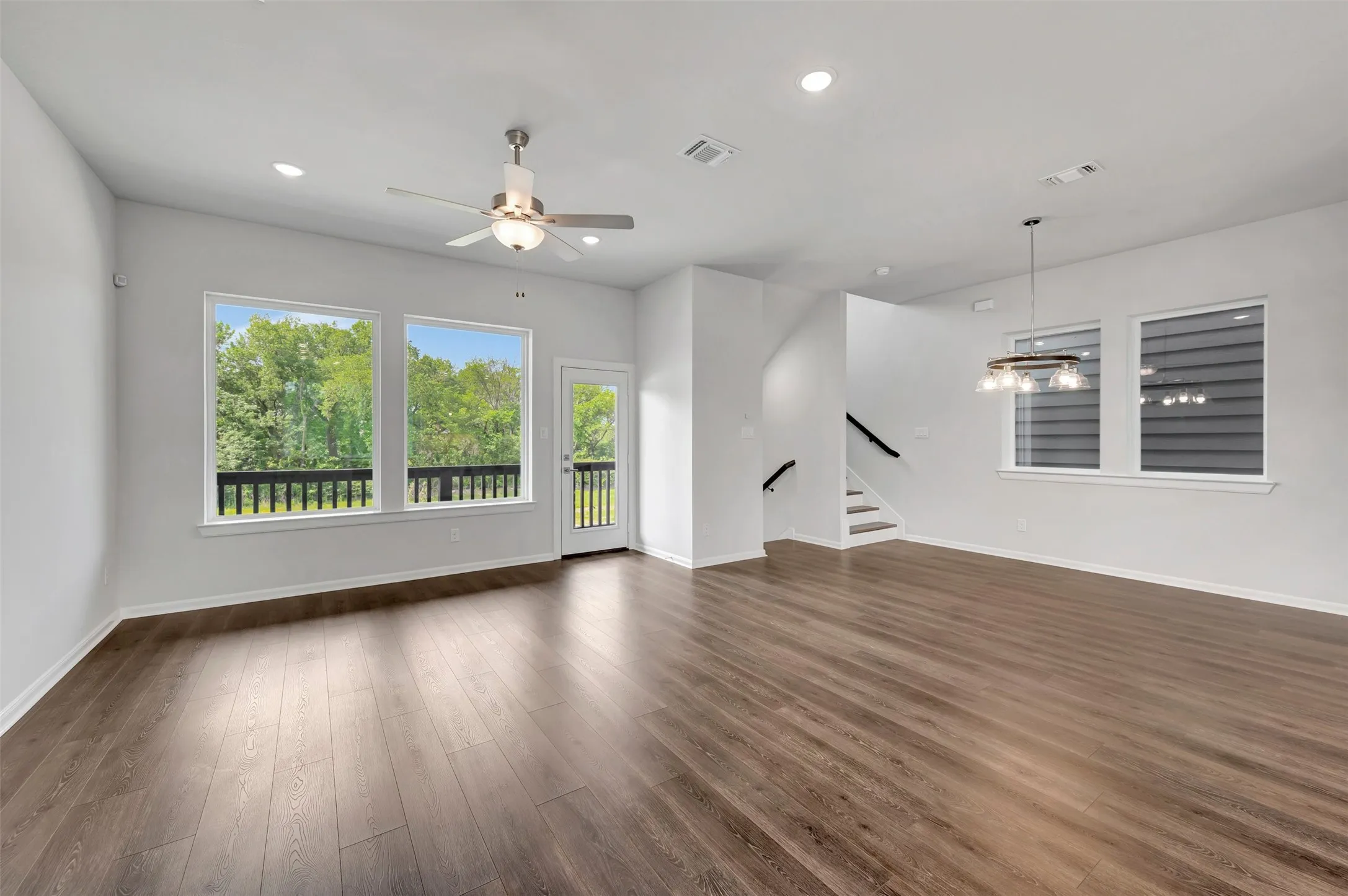 Spacious living area featuring wood-finish flooring, recessed lighting, and a ceiling fan