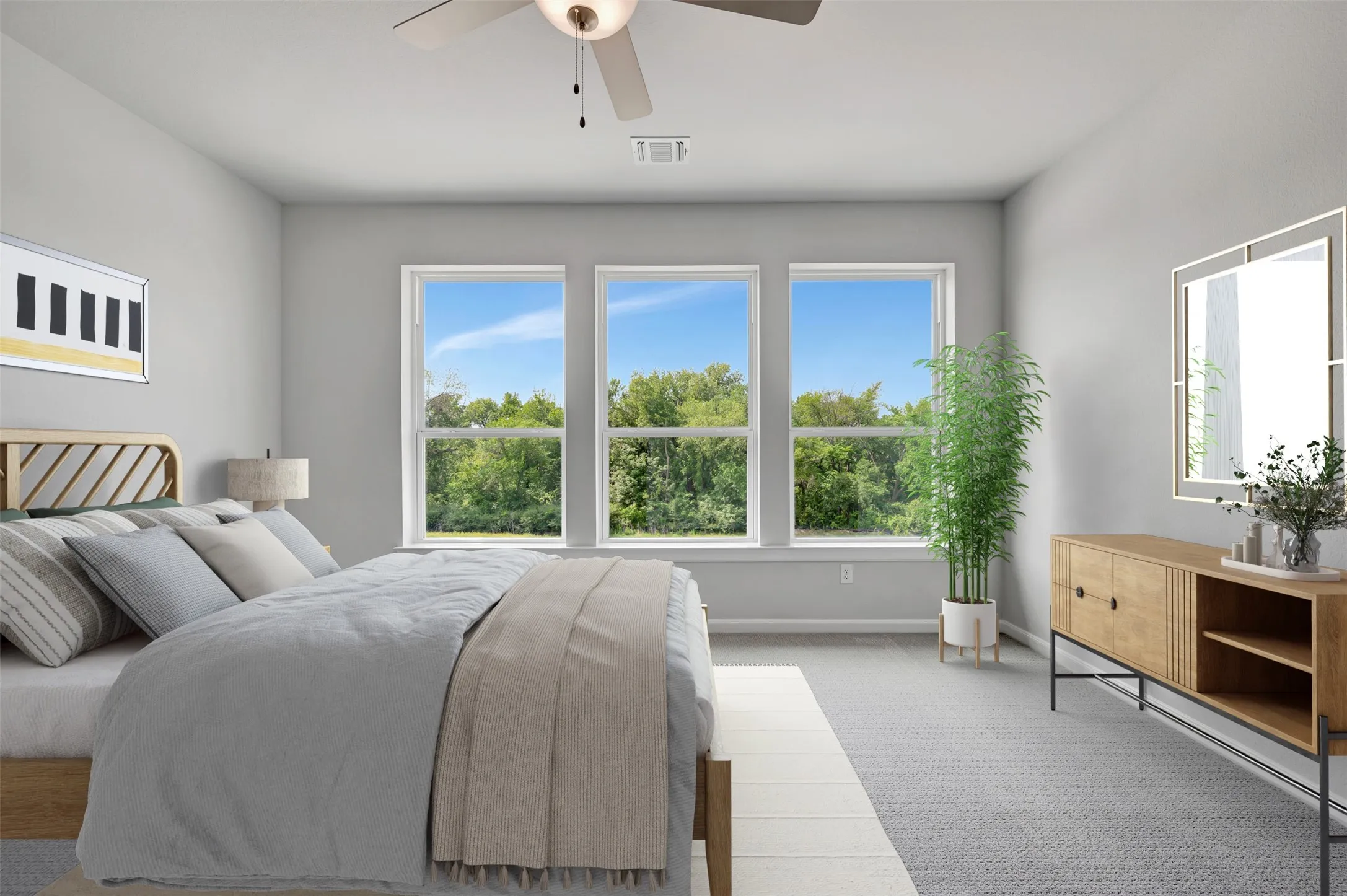 Spacious room featuring three large windows, light gray walls, a ceiling fan with integrated lighting, and neutral-toned carpeting