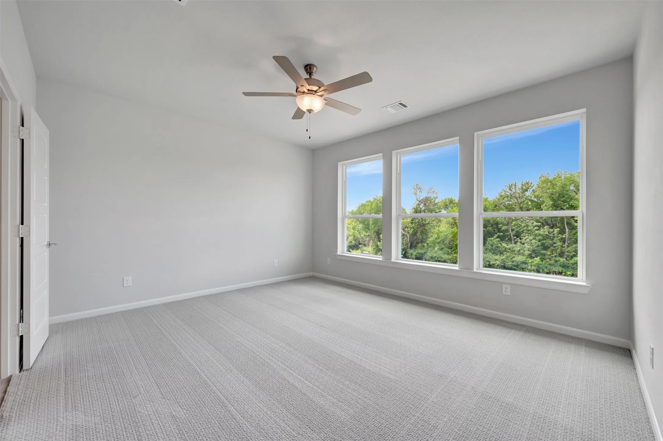 Bright interior space featuring light gray walls and patterned carpeting