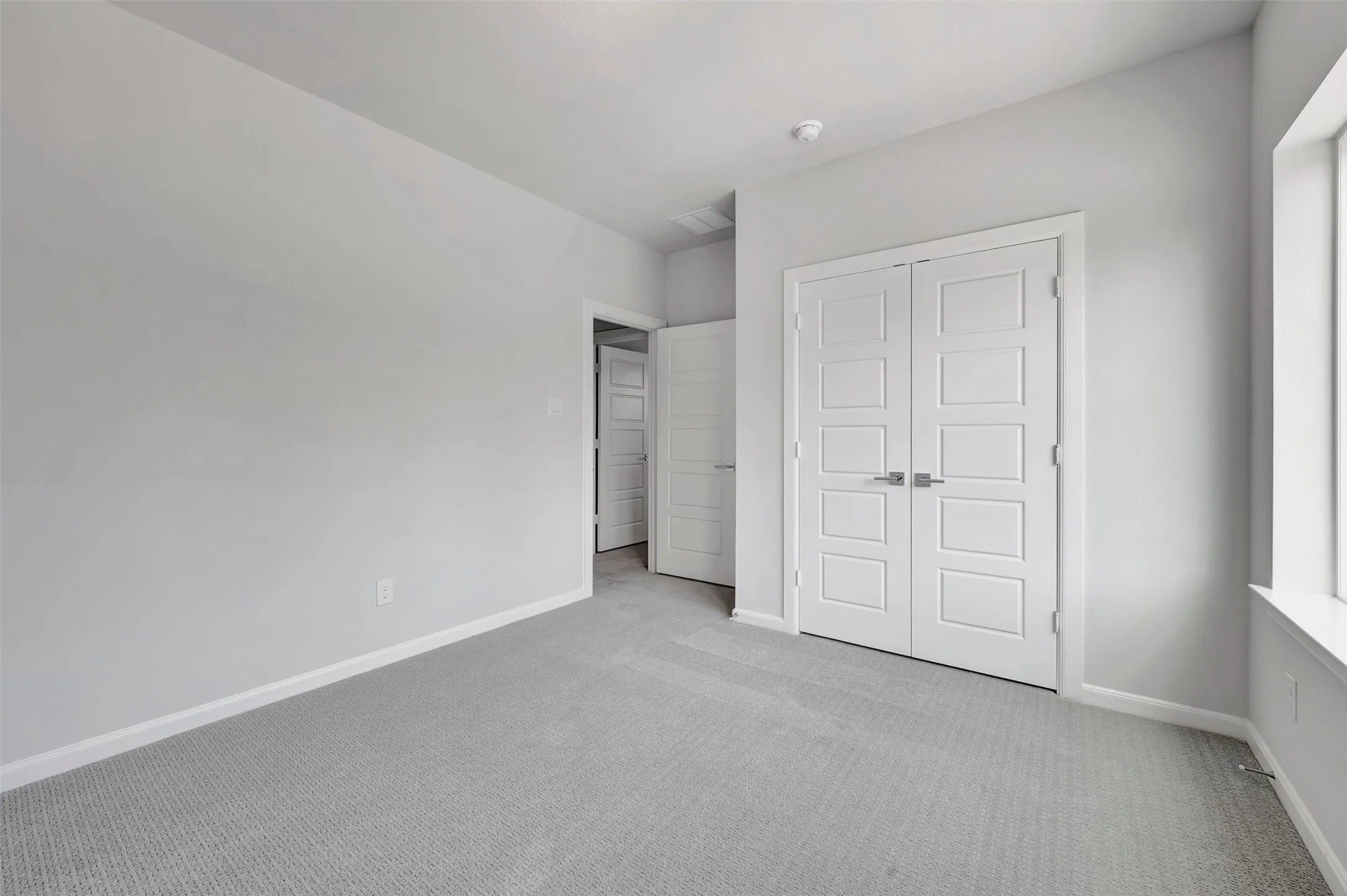 Neutral-toned interior featuring light gray carpeting and white baseboards
