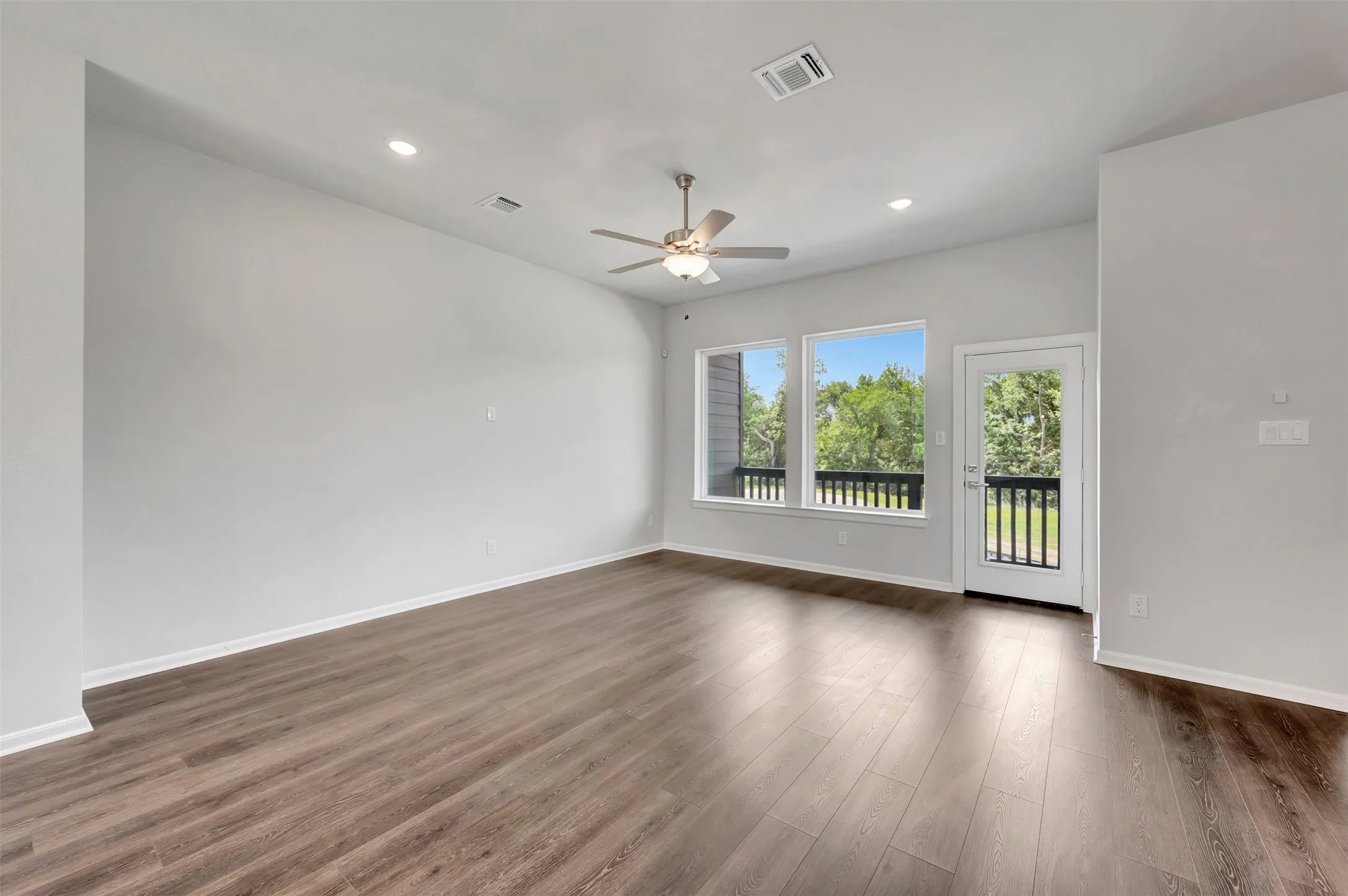 Spacious interior featuring wood-finish flooring, recessed lighting, and a ceiling fan