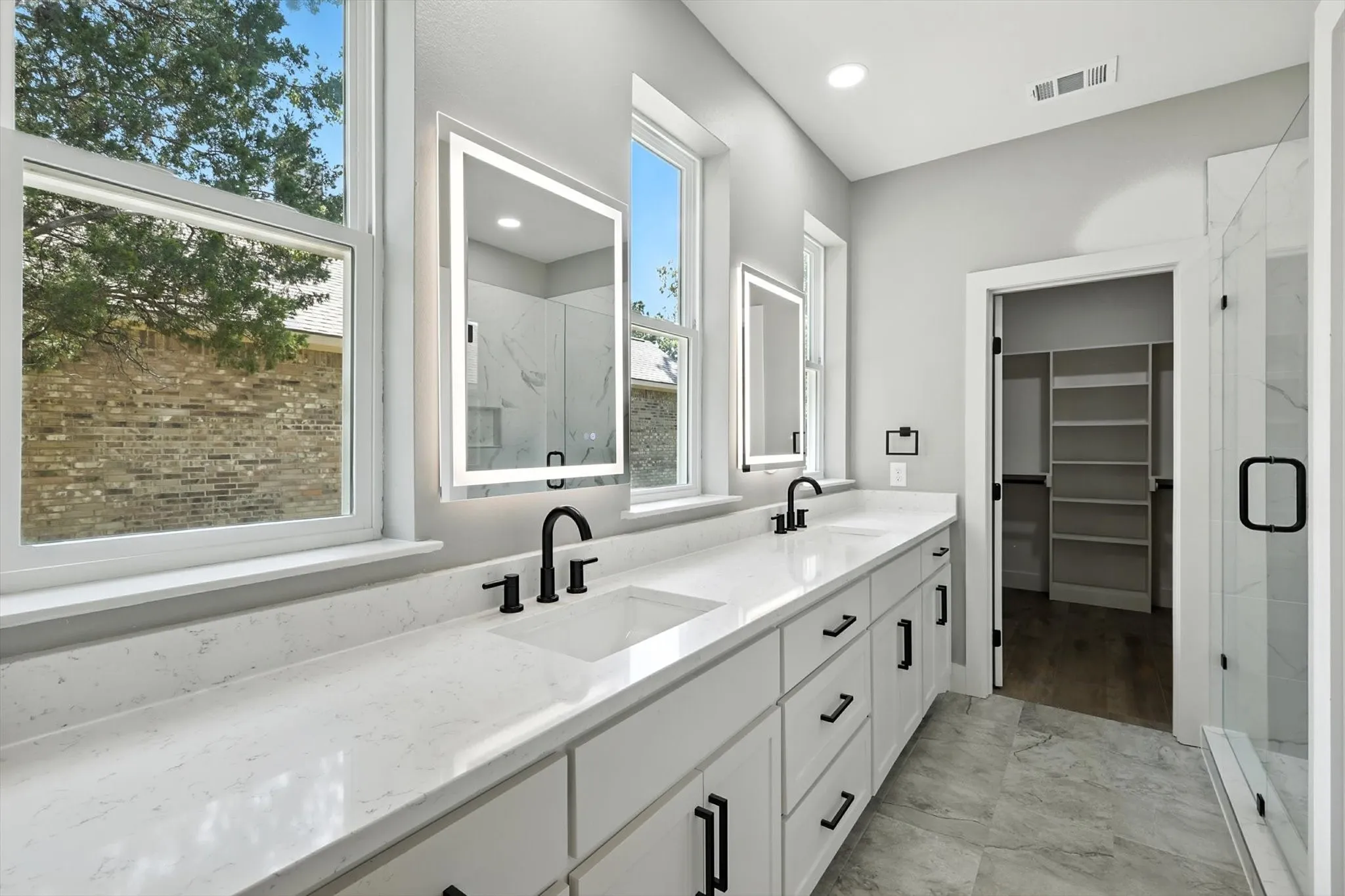 Bathroom with double vanity, a marble finish shower, a walk in closet, and recessed lighting