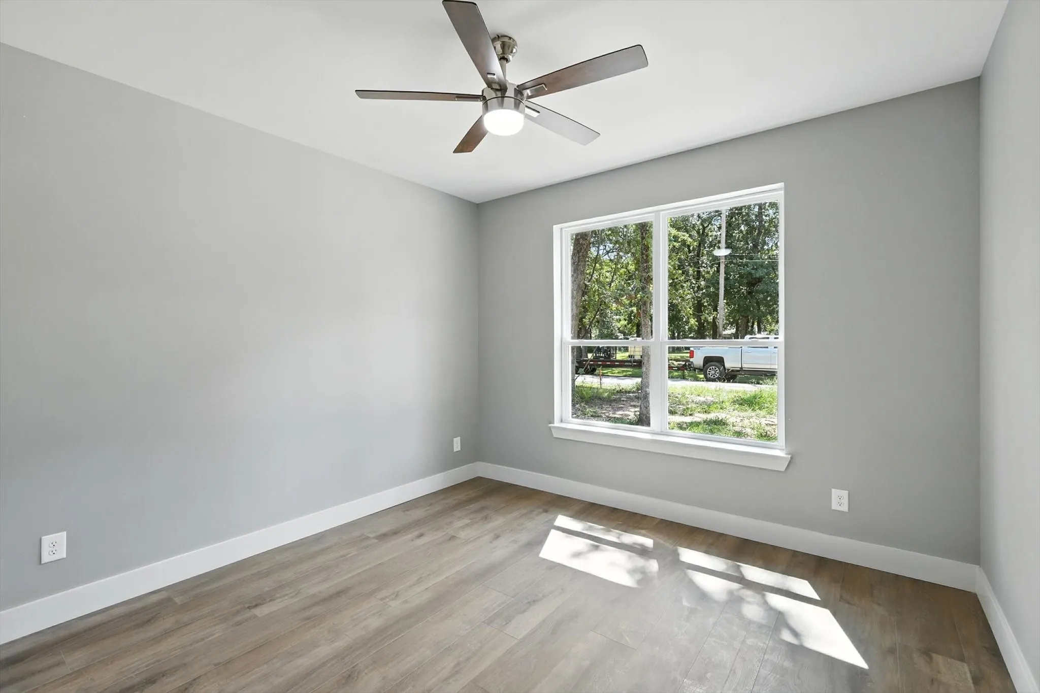 Spare room with wood finished floors and ceiling fan