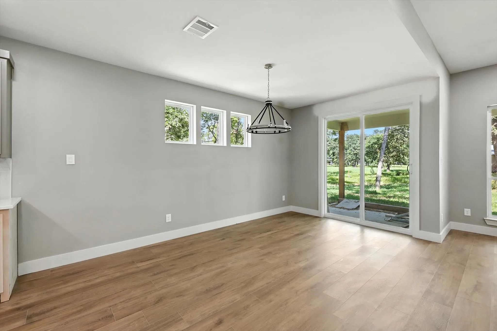 Unfurnished dining area featuring light wood finished floors and a chandelier