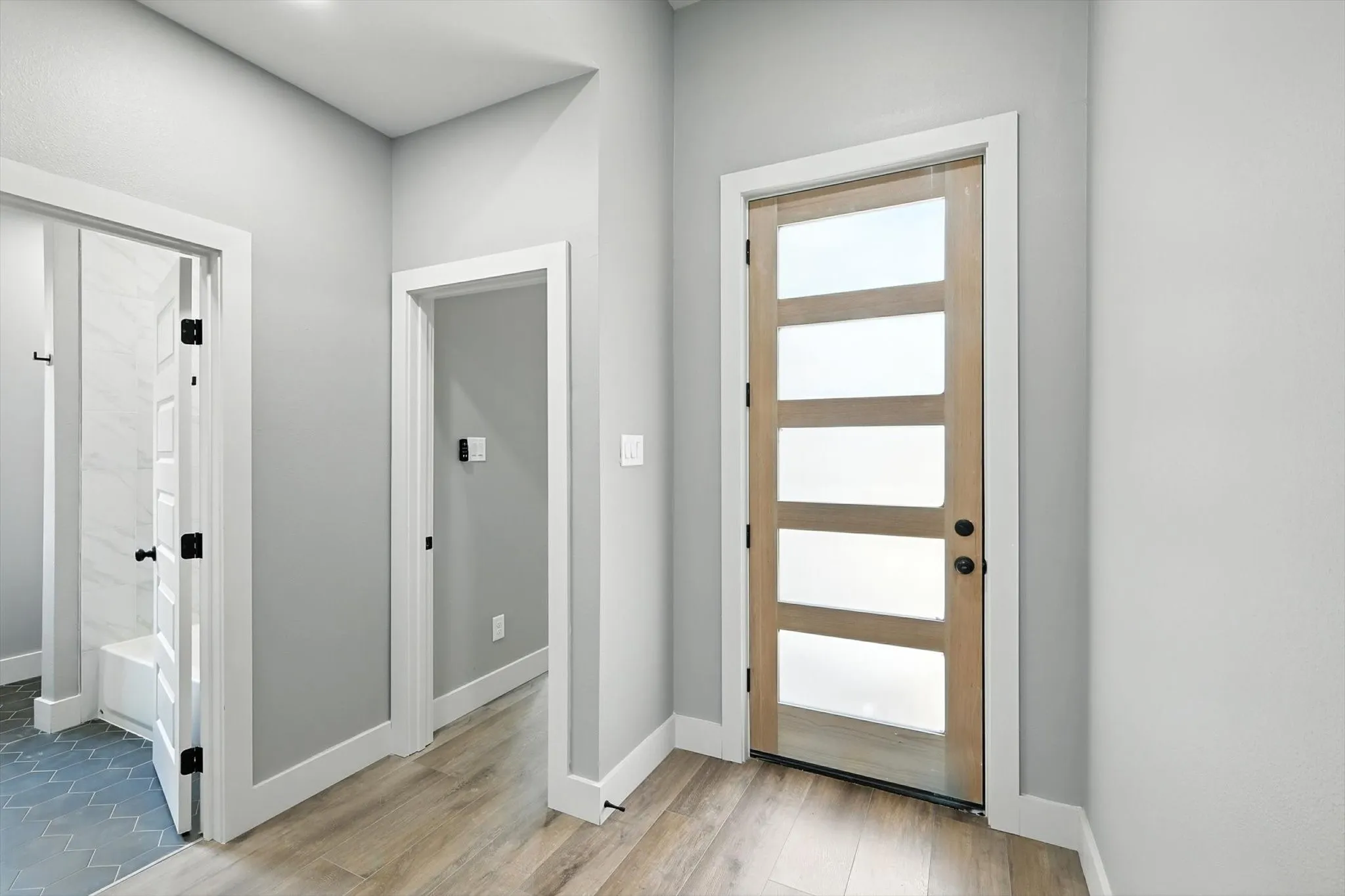 Doorway with baseboards and wood finished floors
