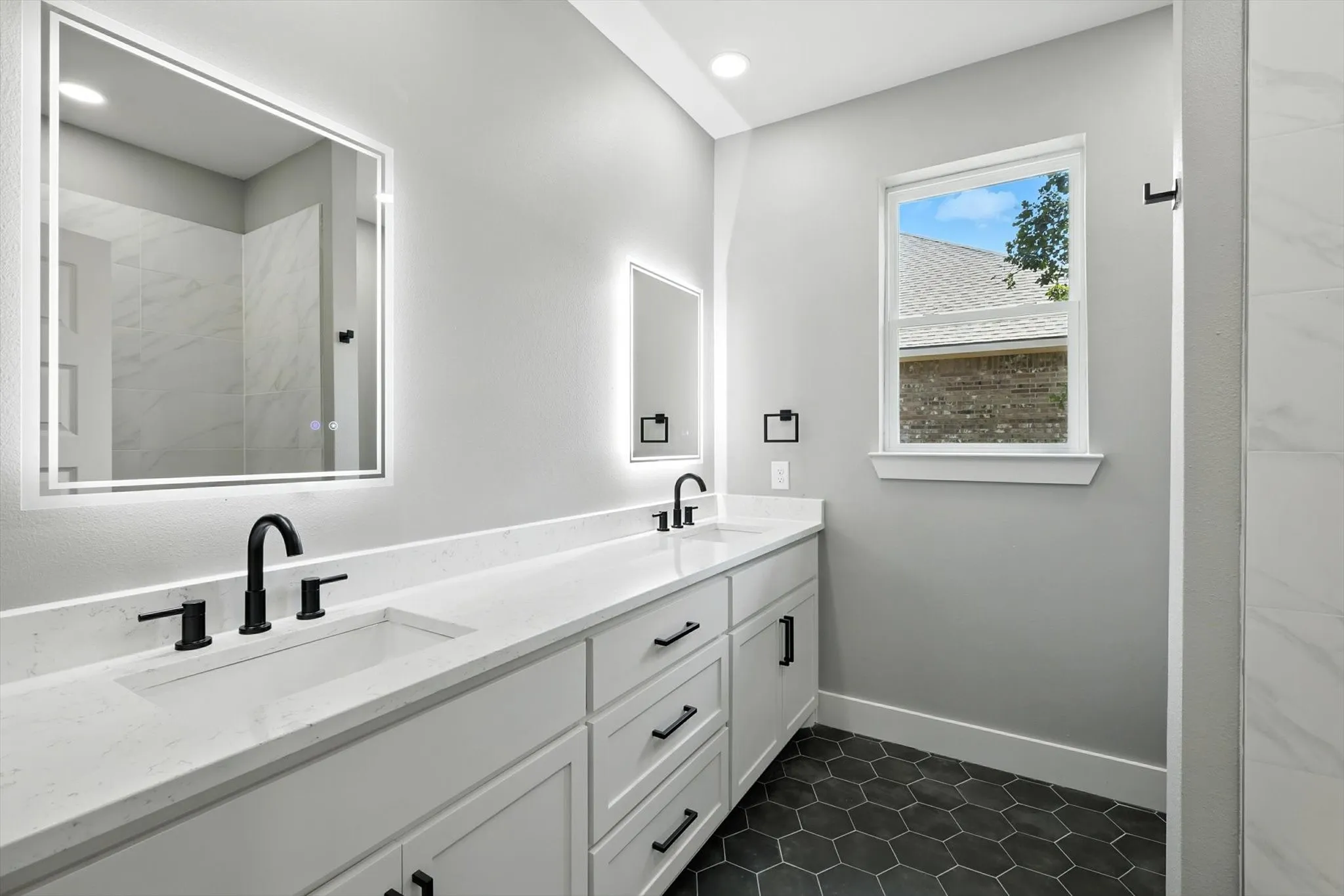Full bathroom featuring double vanity, dark tile patterned flooring, a shower, and recessed lighting
