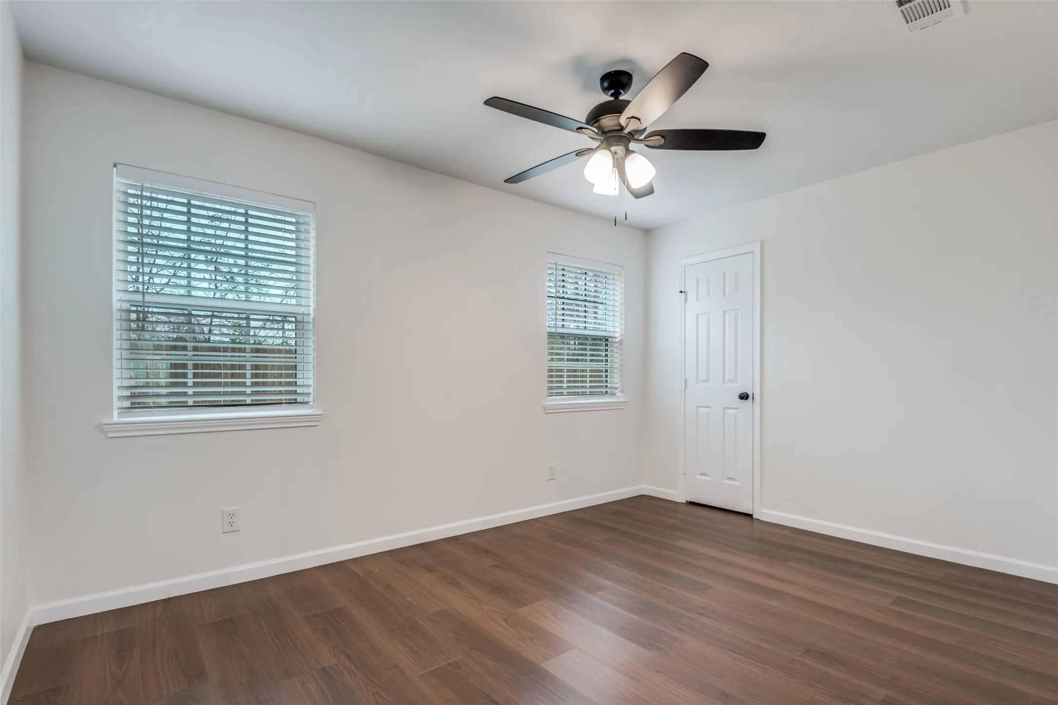 Spare room with dark wood finished floors and a ceiling fan