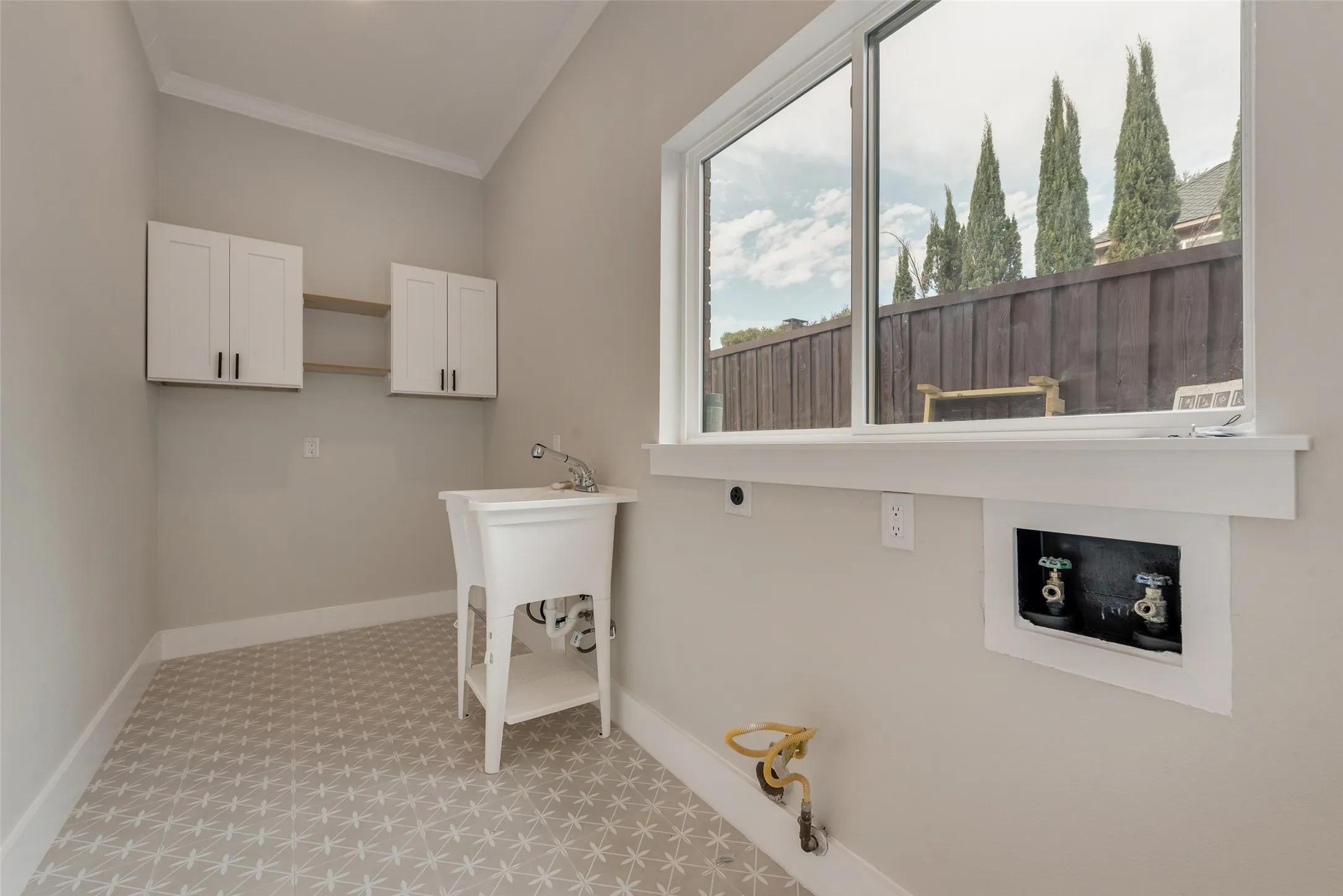 Washroom featuring ornamental molding, washer hookup, light carpet, electric dryer hookup, and cabinet space