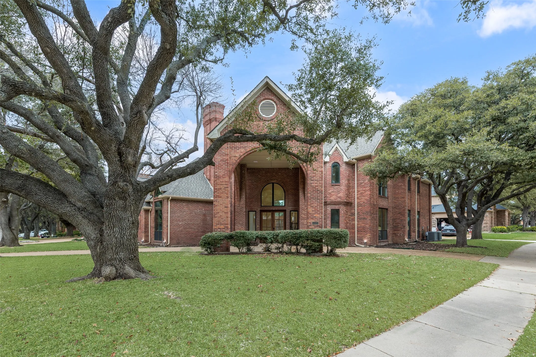 View of front facade featuring a front lawn, brick siding, and a chimney