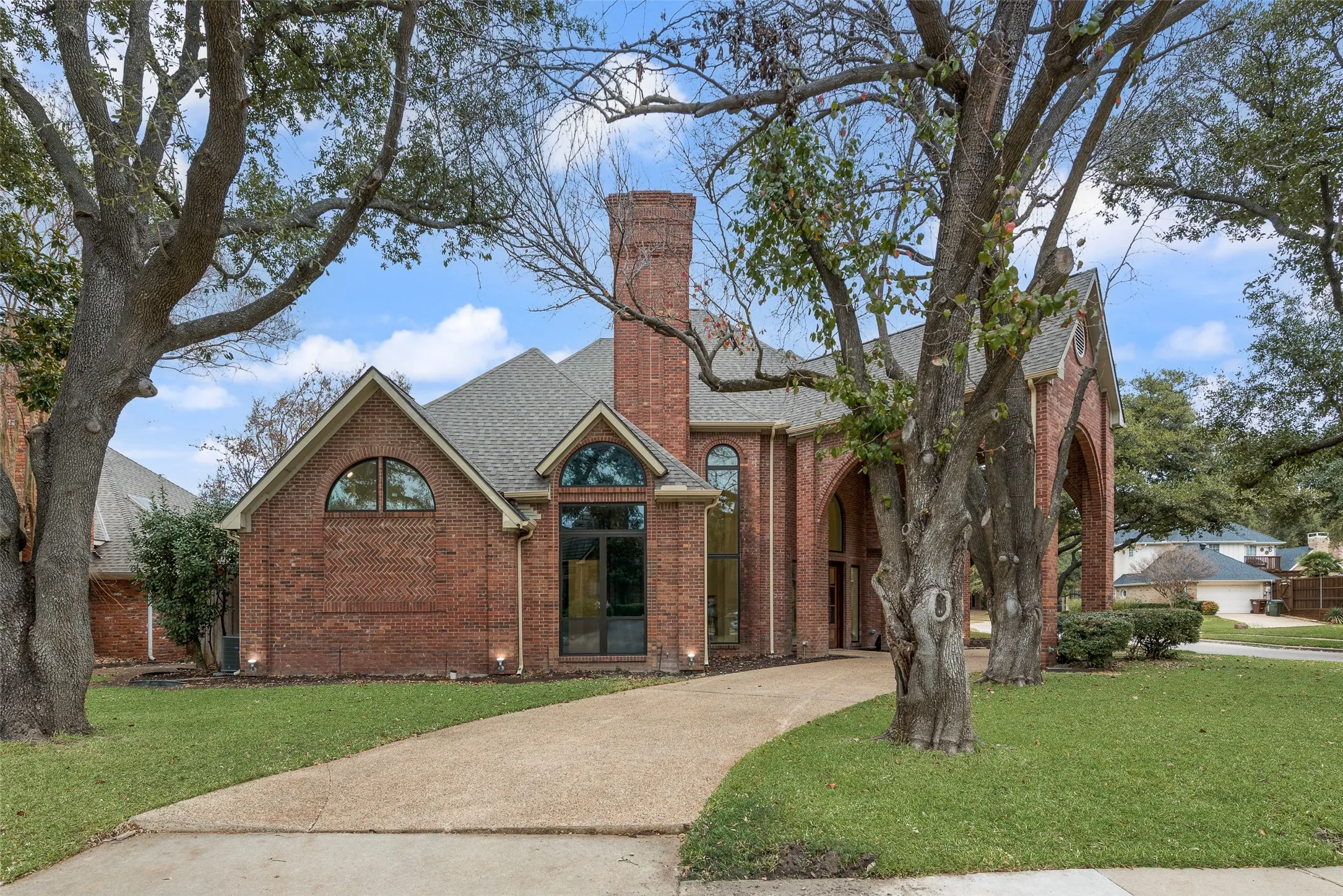 View of front of home featuring a front lawn, brick siding, and a chimney