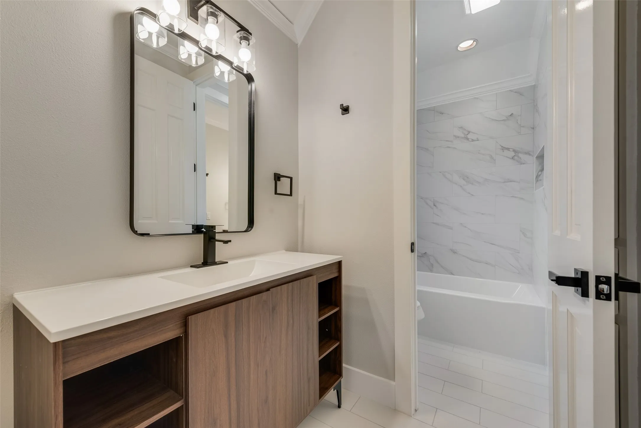 Full bathroom featuring vanity, bathtub / shower combination, and ornamental molding
