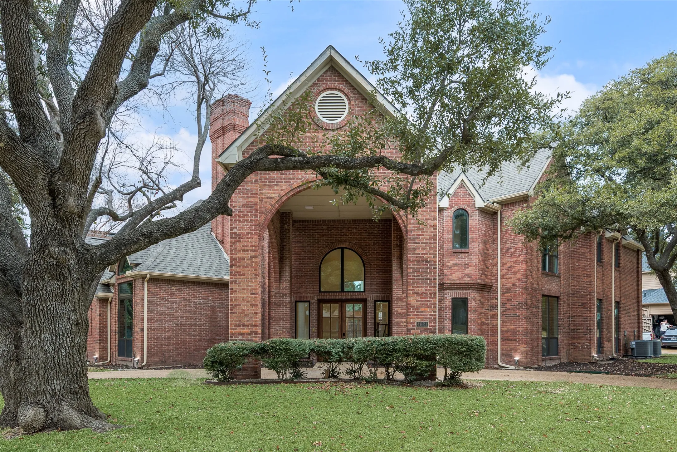 View of front of home featuring a front yard, brick siding, and a chimney