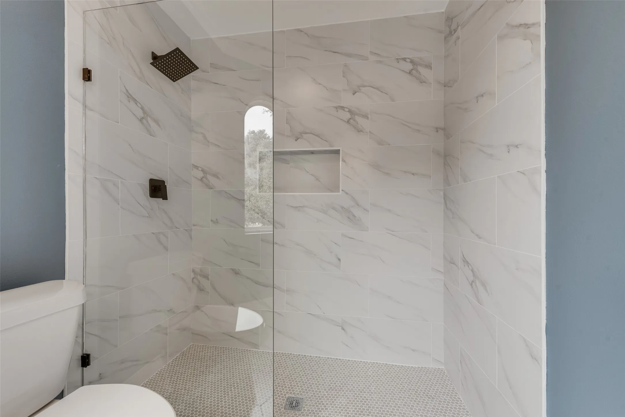 Bathroom featuring a marble finish shower and toilet