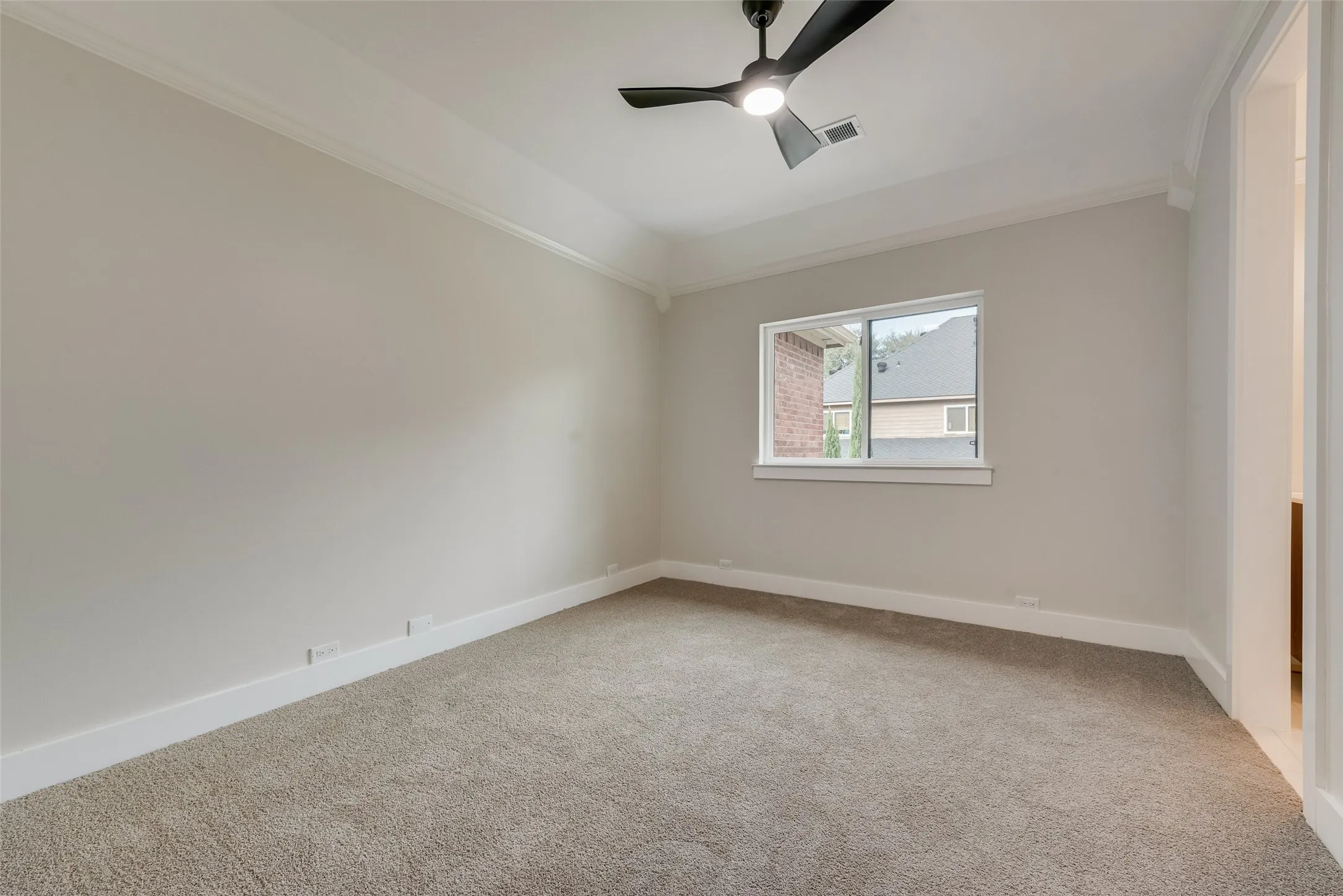 Empty room featuring ornamental molding, light carpet, and ceiling fan