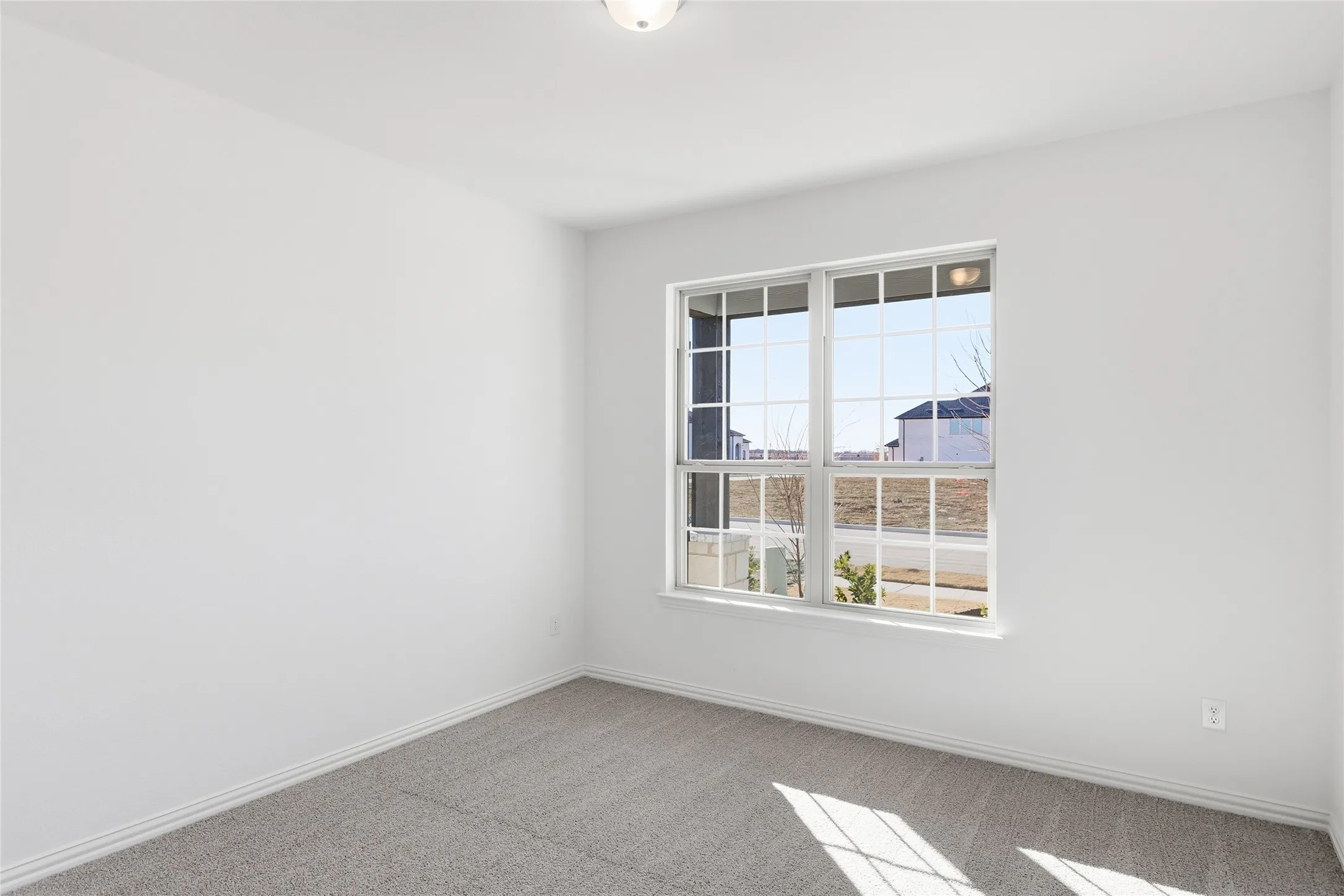Bright room with white painted walls and gray carpet flooring