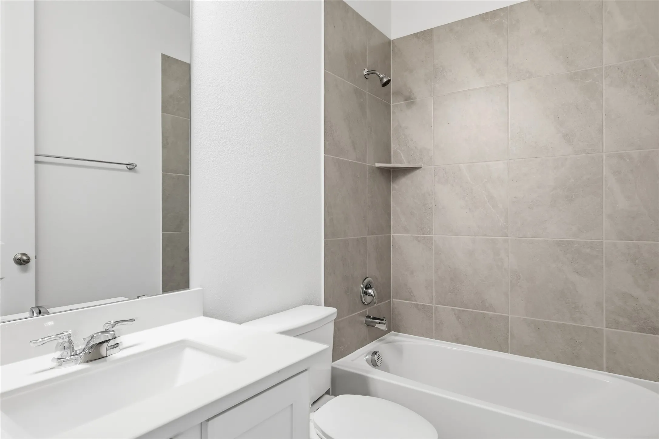Bathroom featuring a white vanity with integrated sink, chrome faucet, and full-width mirror