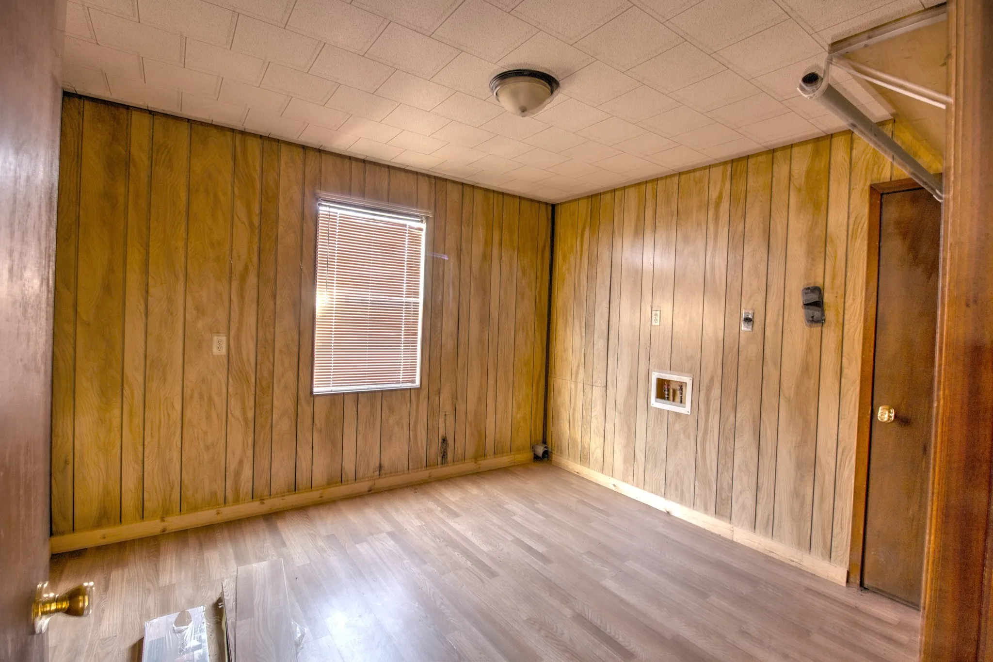 Empty room featuring light wood finished floors and wooden walls