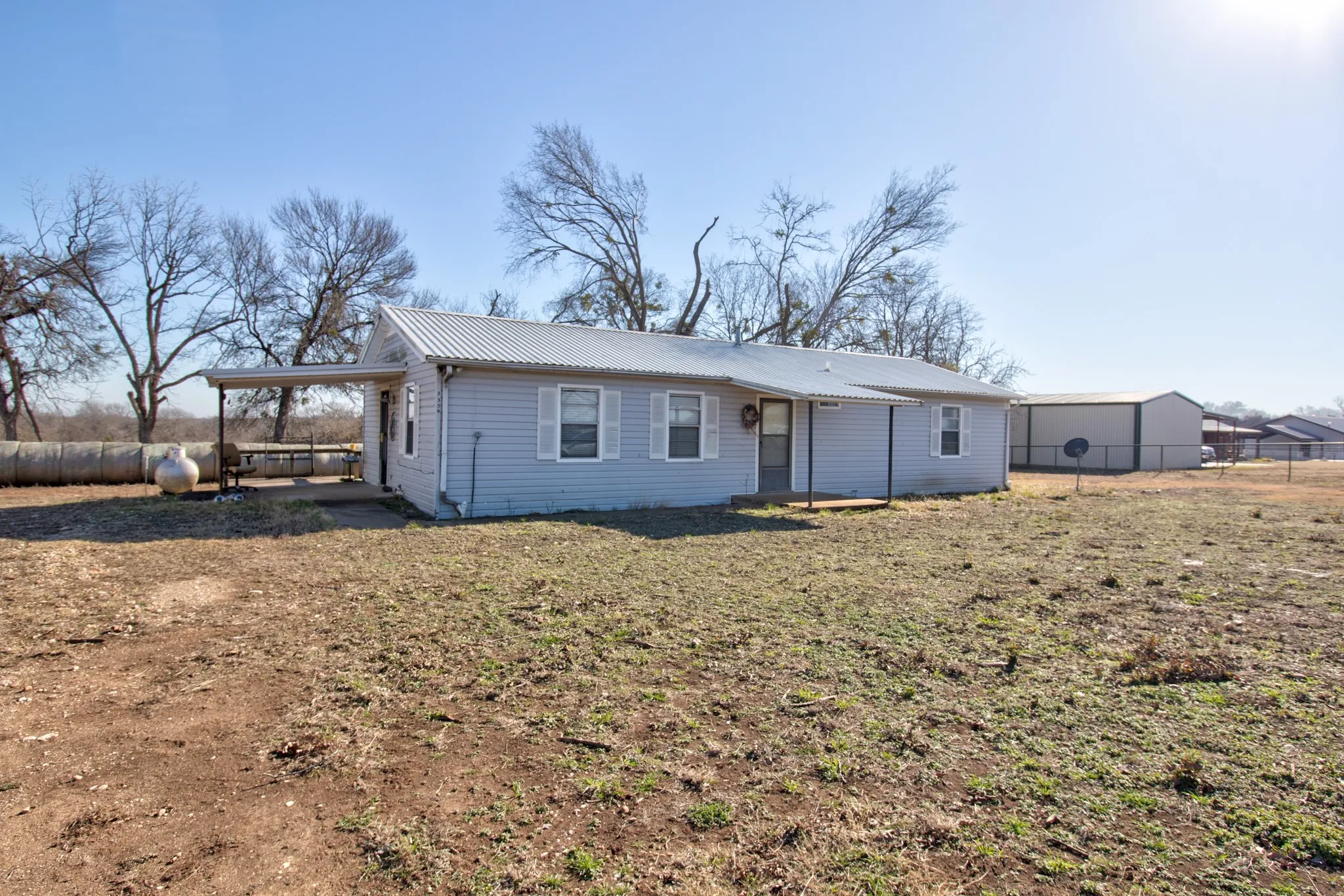 Rear view of property with a metal roof and an attached carport