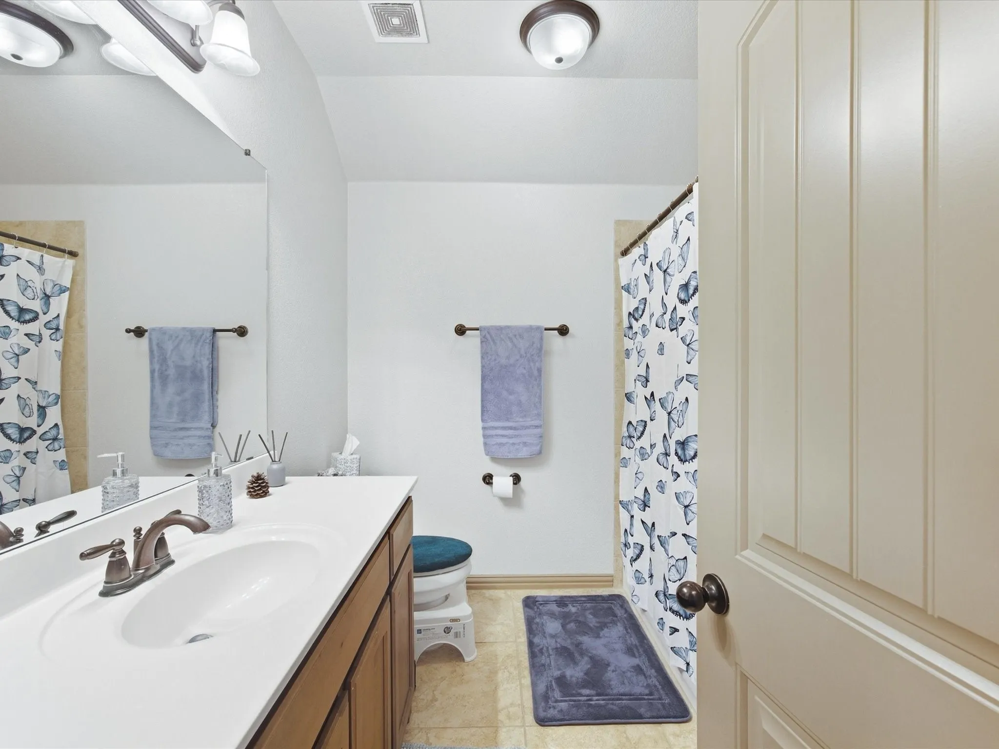 White countertop vanity with integrated sink and bronze-finish faucet