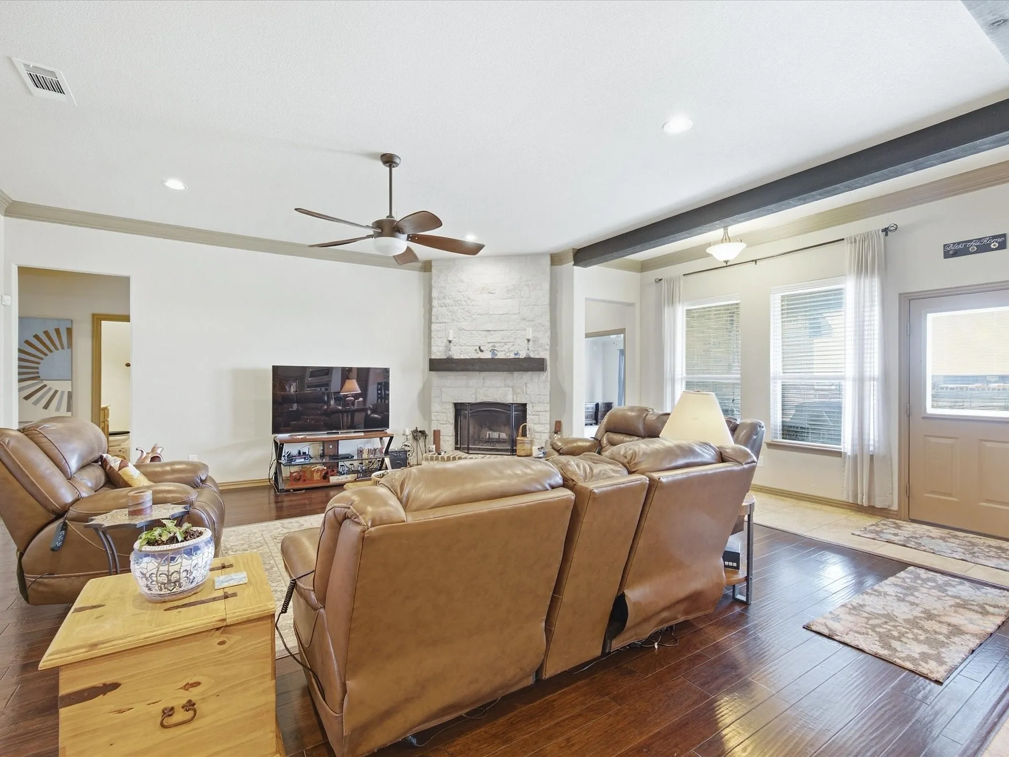 Wood-finish flooring throughout, complemented by a white stone fireplace with a wood mantle