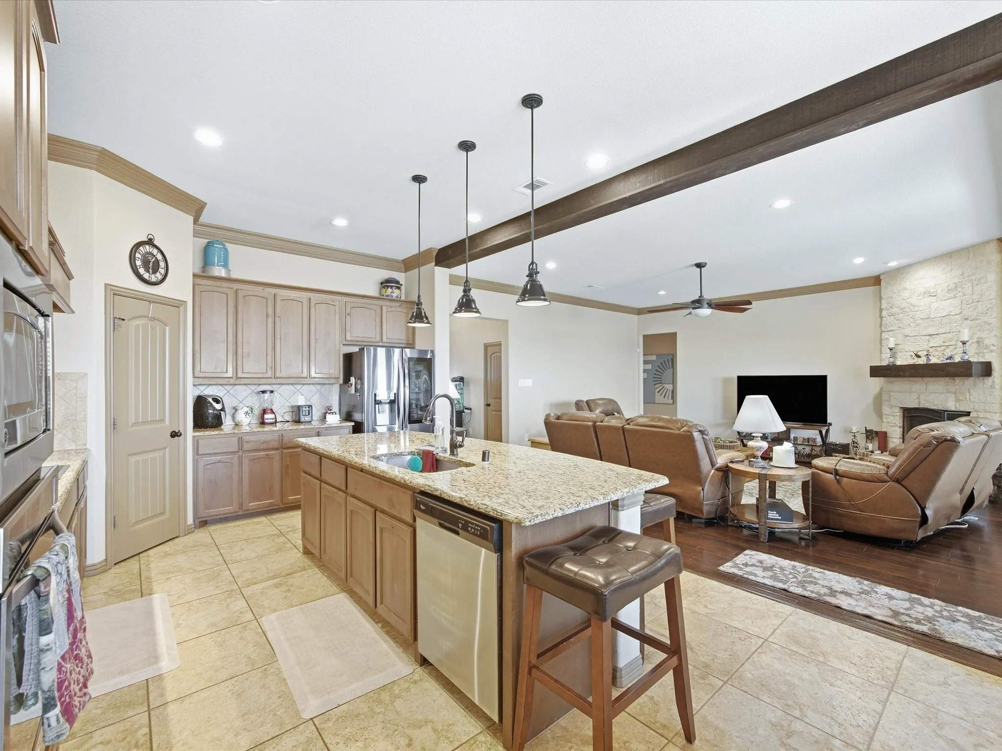 Kitchen island with granite countertop, integrated sink, and pendant lighting