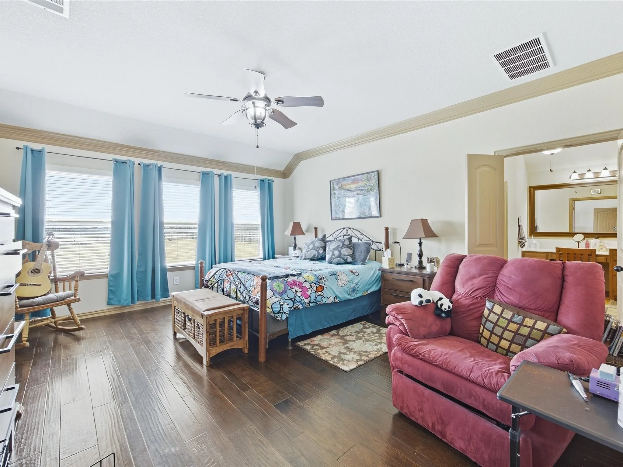 Spacious room featuring wood-finish flooring, a tray ceiling, and multiple windows