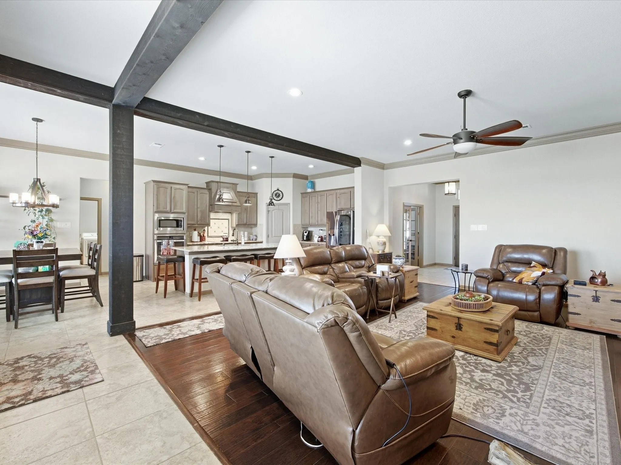 Open-concept living area with dark wood-finish flooring, recessed lighting, and a ceiling fan