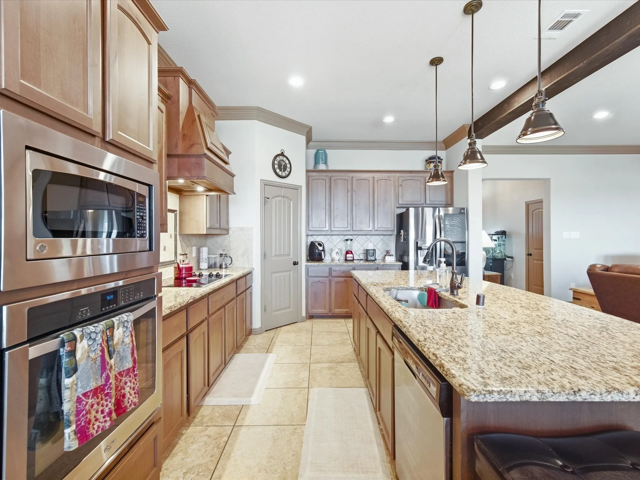 Kitchen featuring a large island with an undermount sink, stainless steel appliances, recessed lighting, and tile flooring