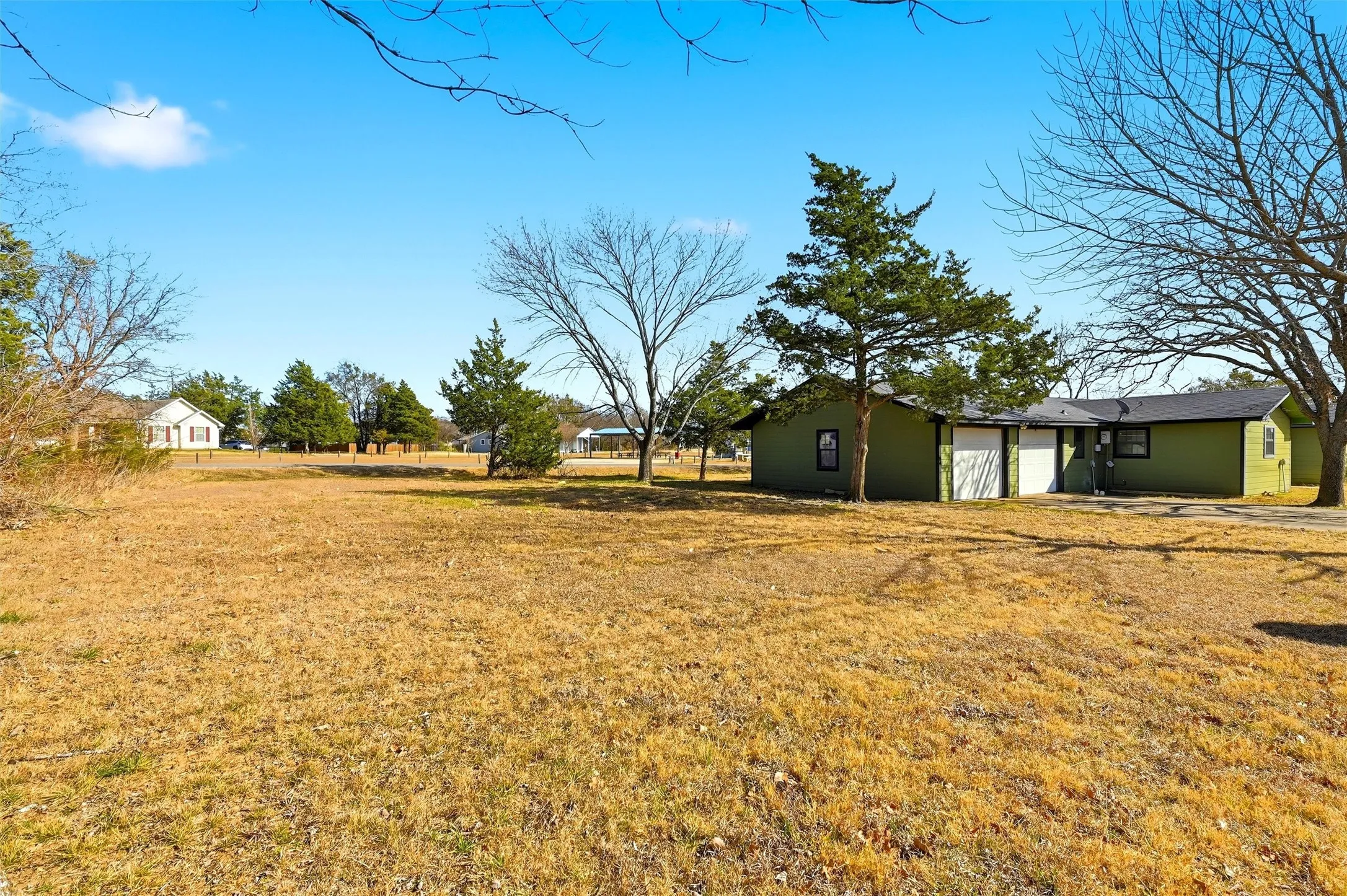 View of grassy yard featuring a garage