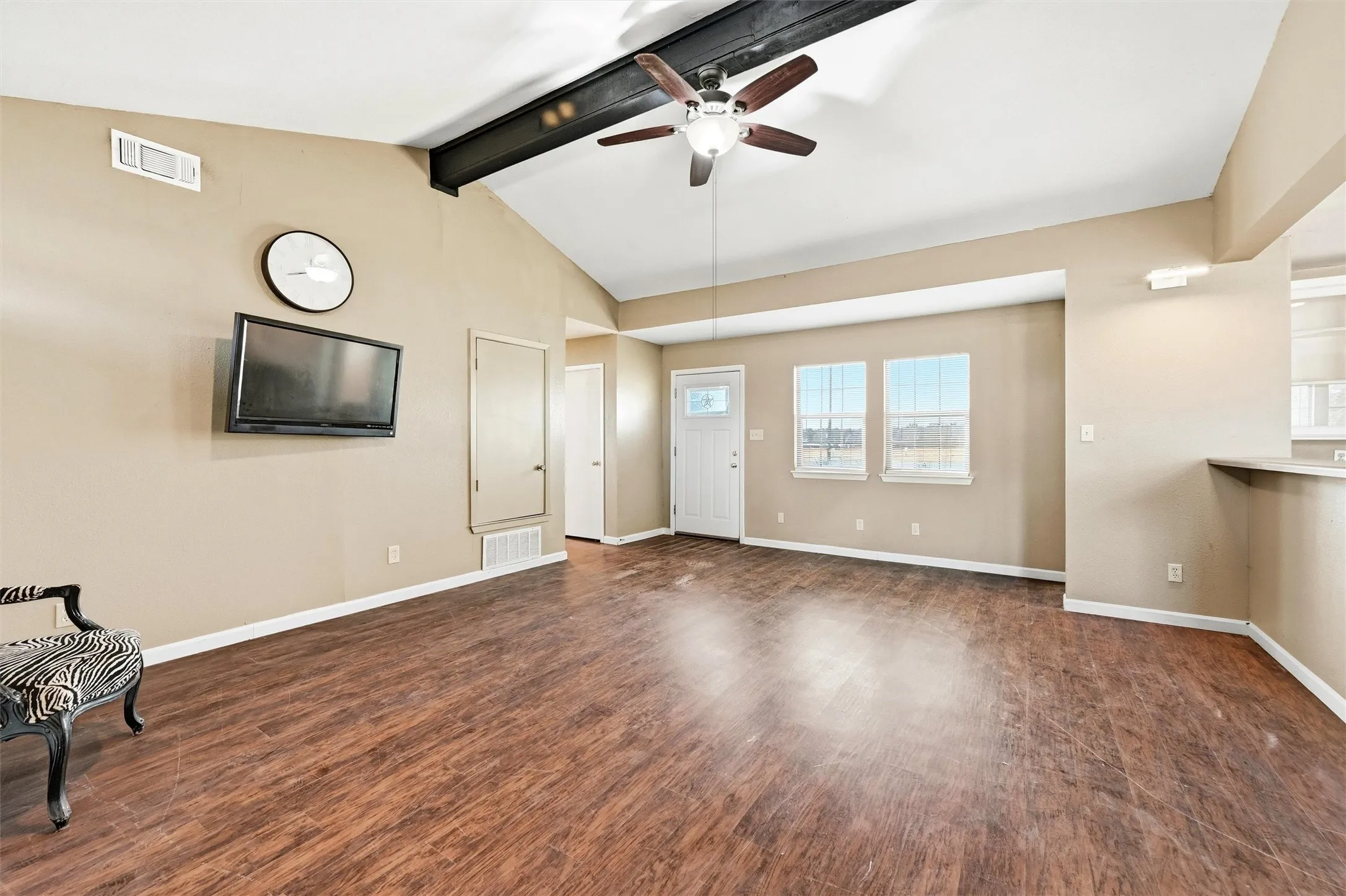 Unfurnished living room featuring a ceiling fan and dark wood finished floors