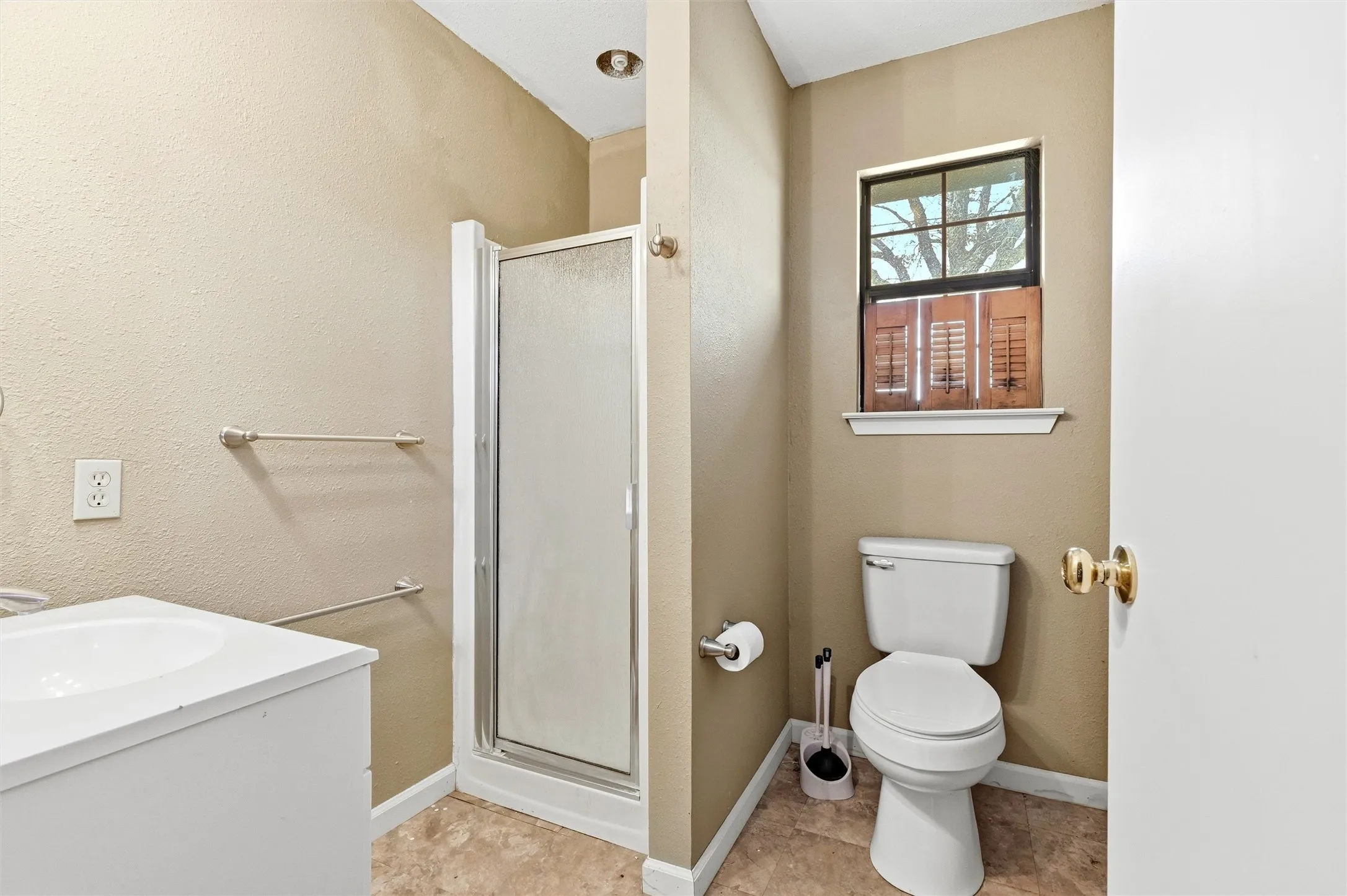 Bathroom with vanity, a stall shower, and a textured wall