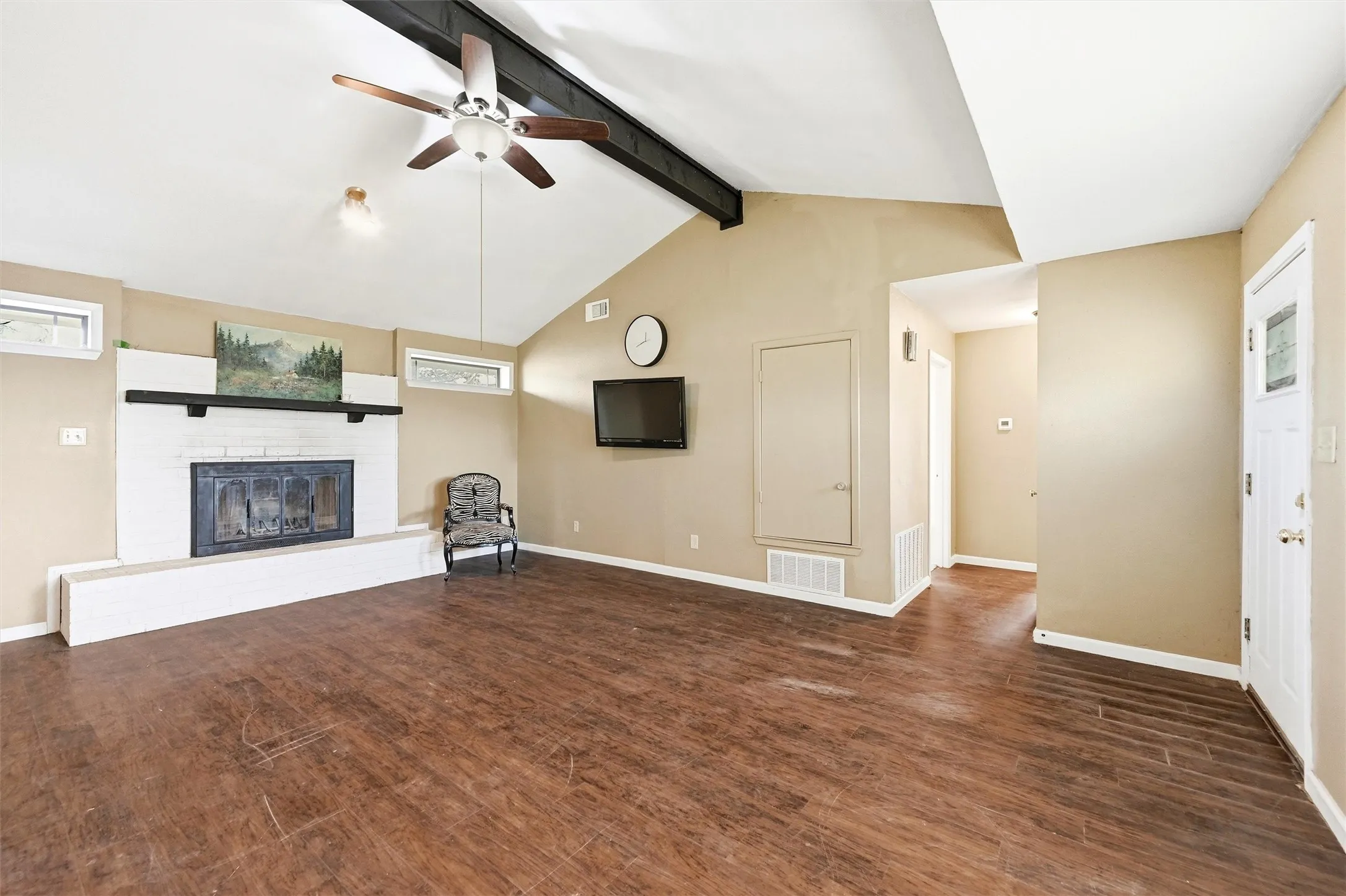 Unfurnished living room featuring ceiling fan, a glass covered fireplace, and dark wood finished floors