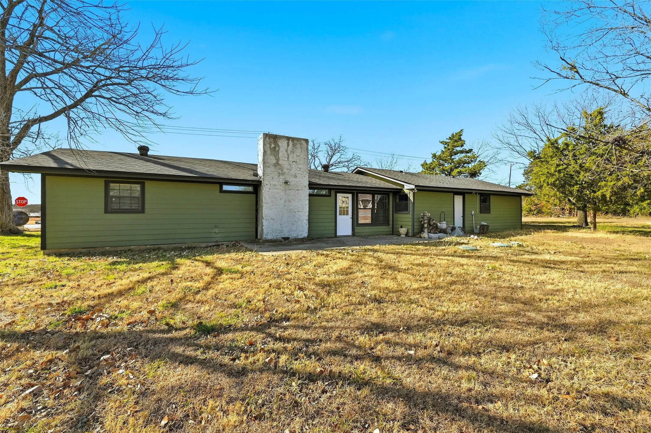 Rear view of house featuring a lawn and a chimney
