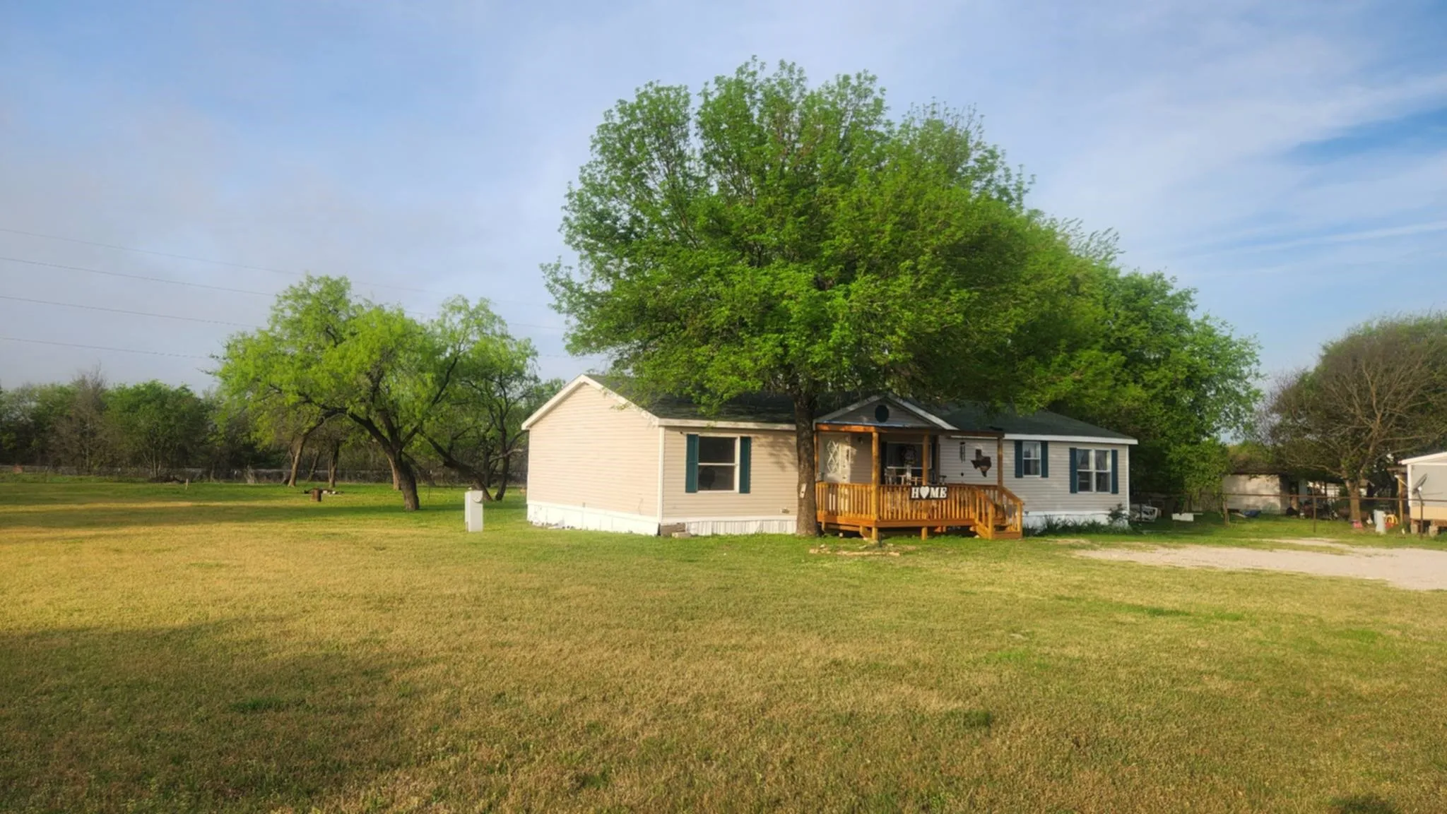 Manufactured / mobile home featuring a deck and a front yard
