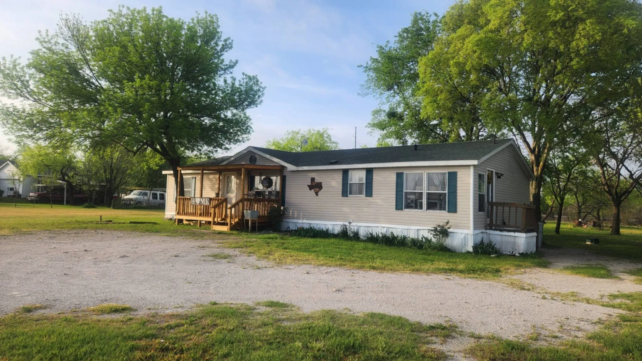 Manufactured / mobile home featuring a front lawn and a deck