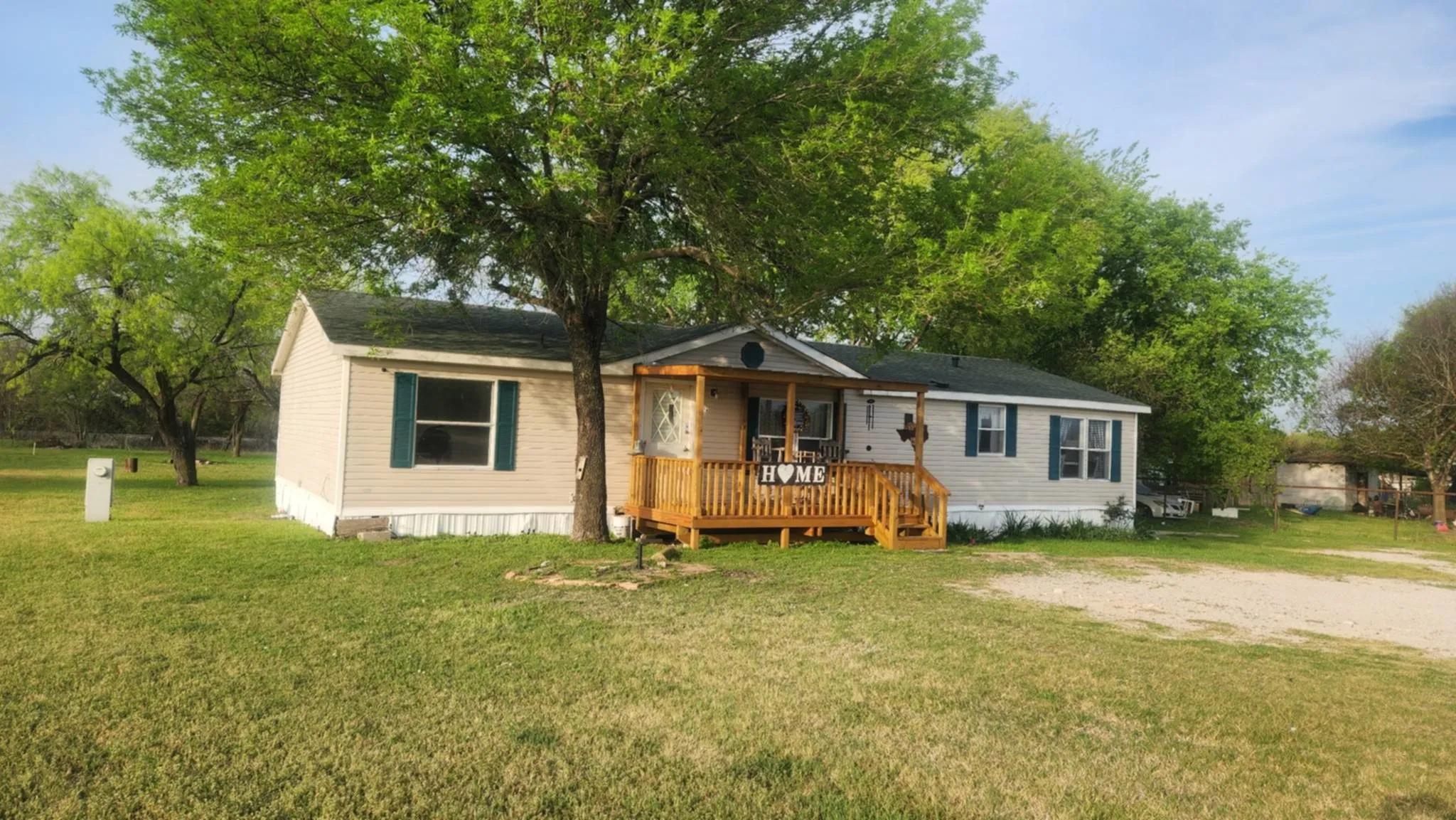 Manufactured / mobile home featuring a deck and a front yard