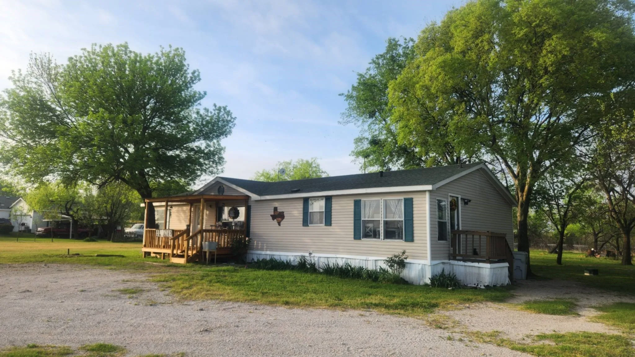 Manufactured / mobile home with a front yard and a wooden deck
