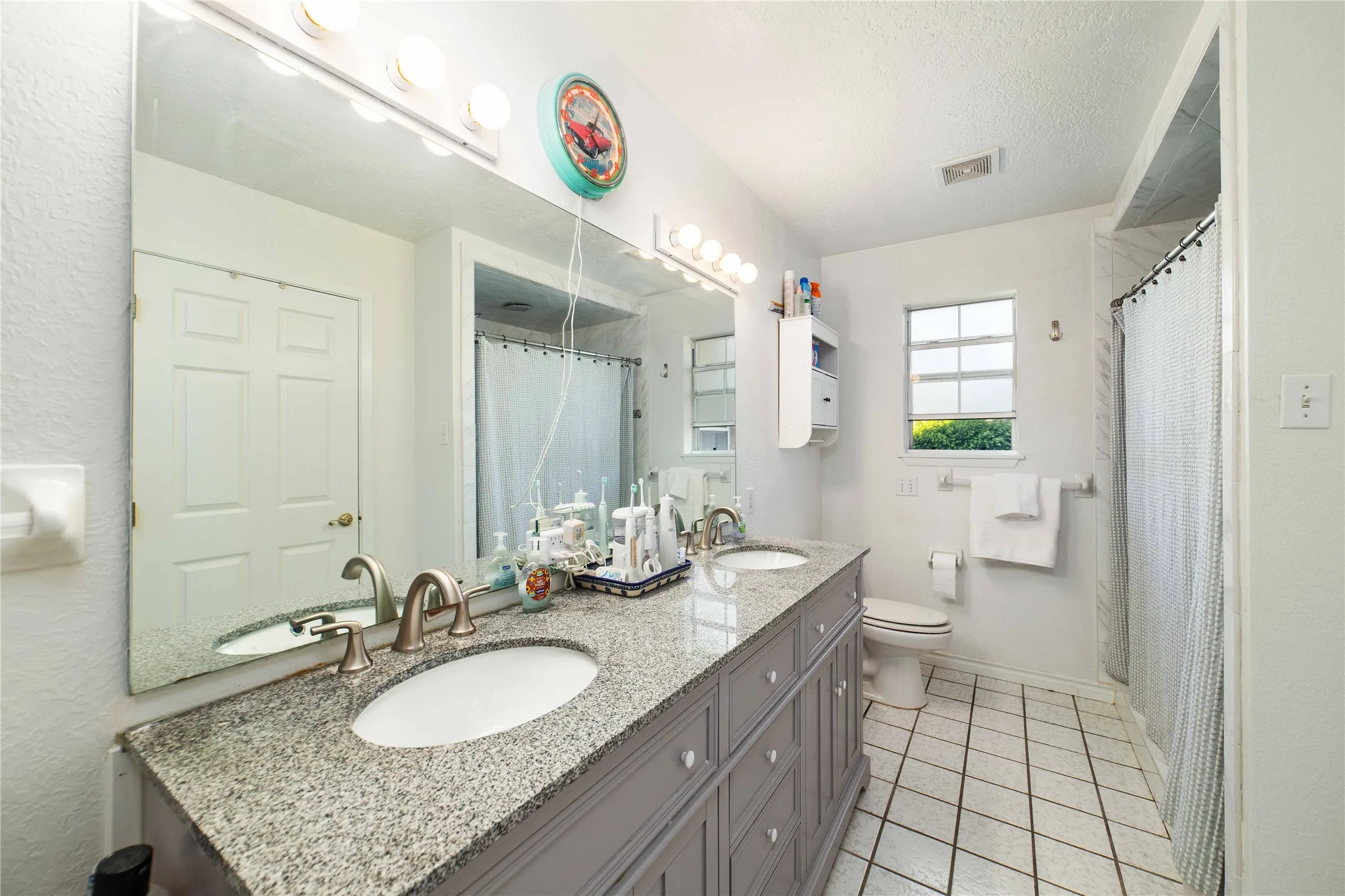Full bath featuring toilet, a sink, and visible vents