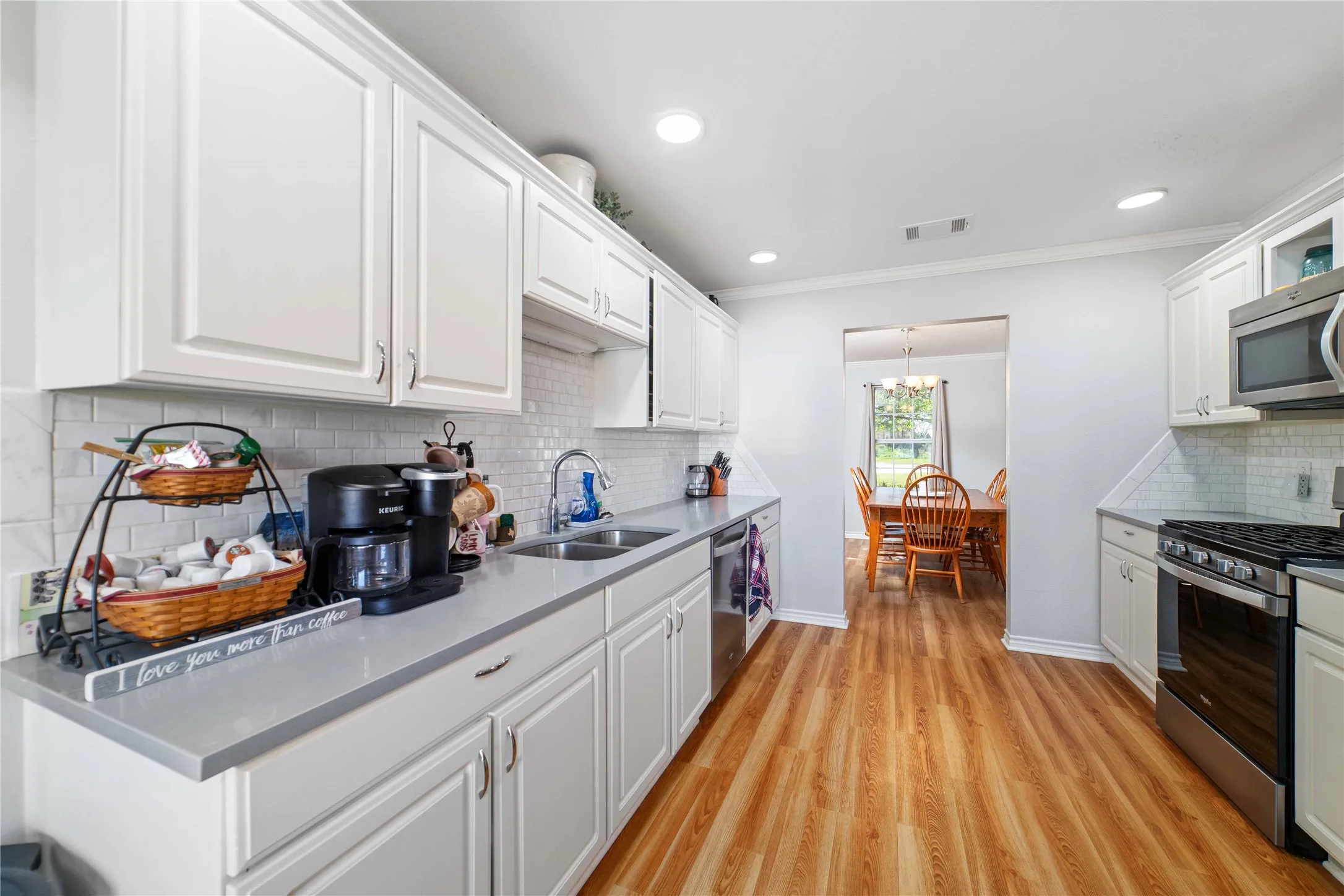 Kitchen featuring stainless steel appliances, visible vents, a sink, and white cabinetry