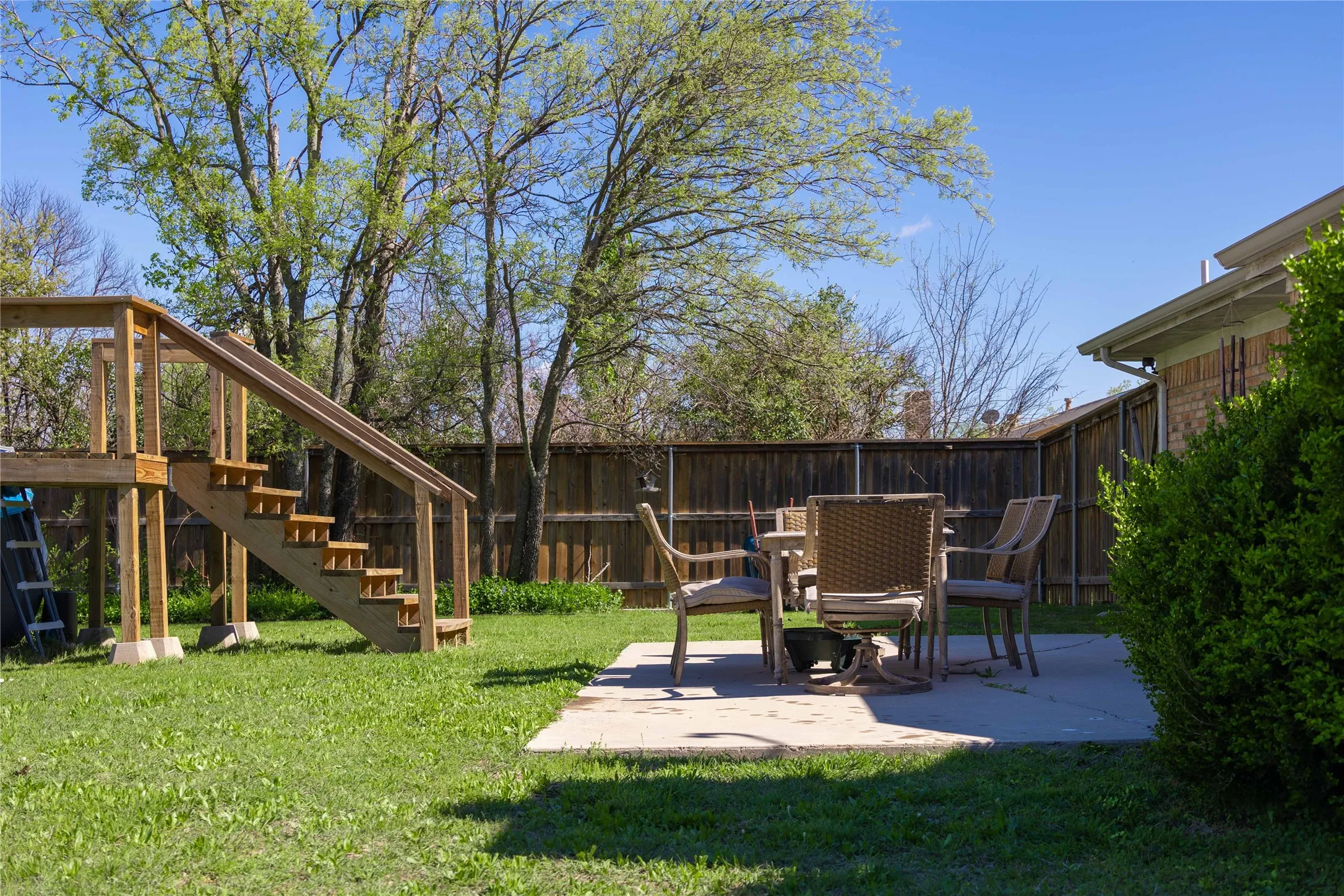 View of yard featuring stairway, fence, and a patio