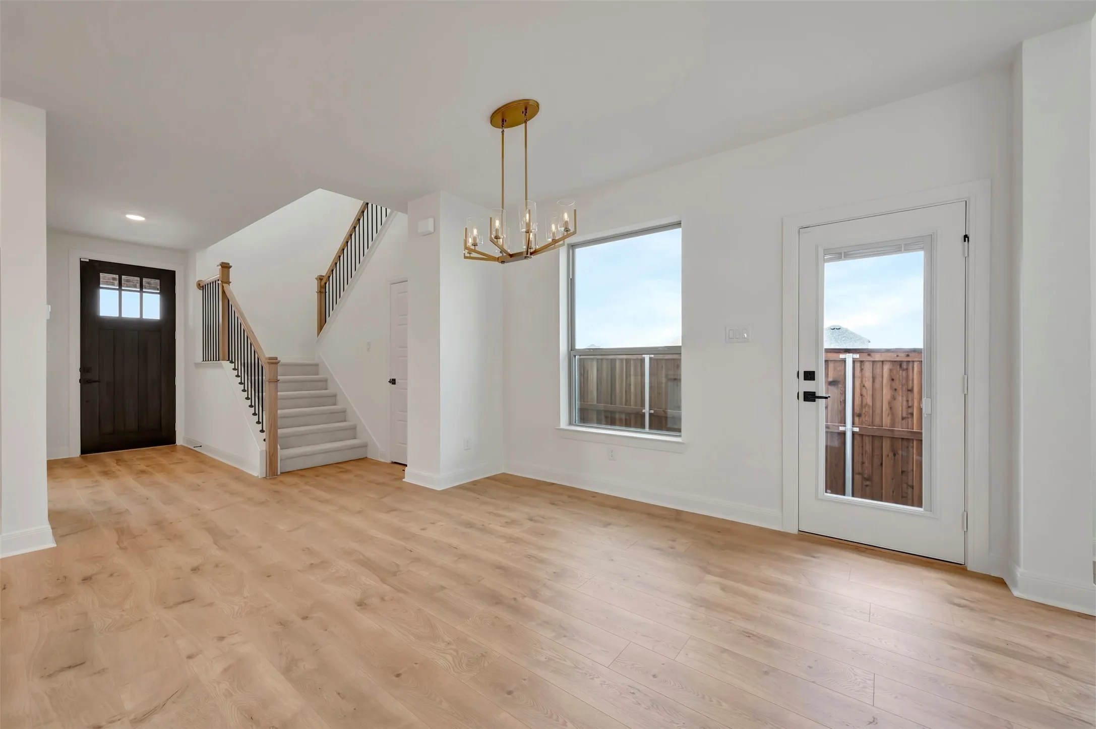 Foyer entrance featuring hanging lights and light wood-style floors