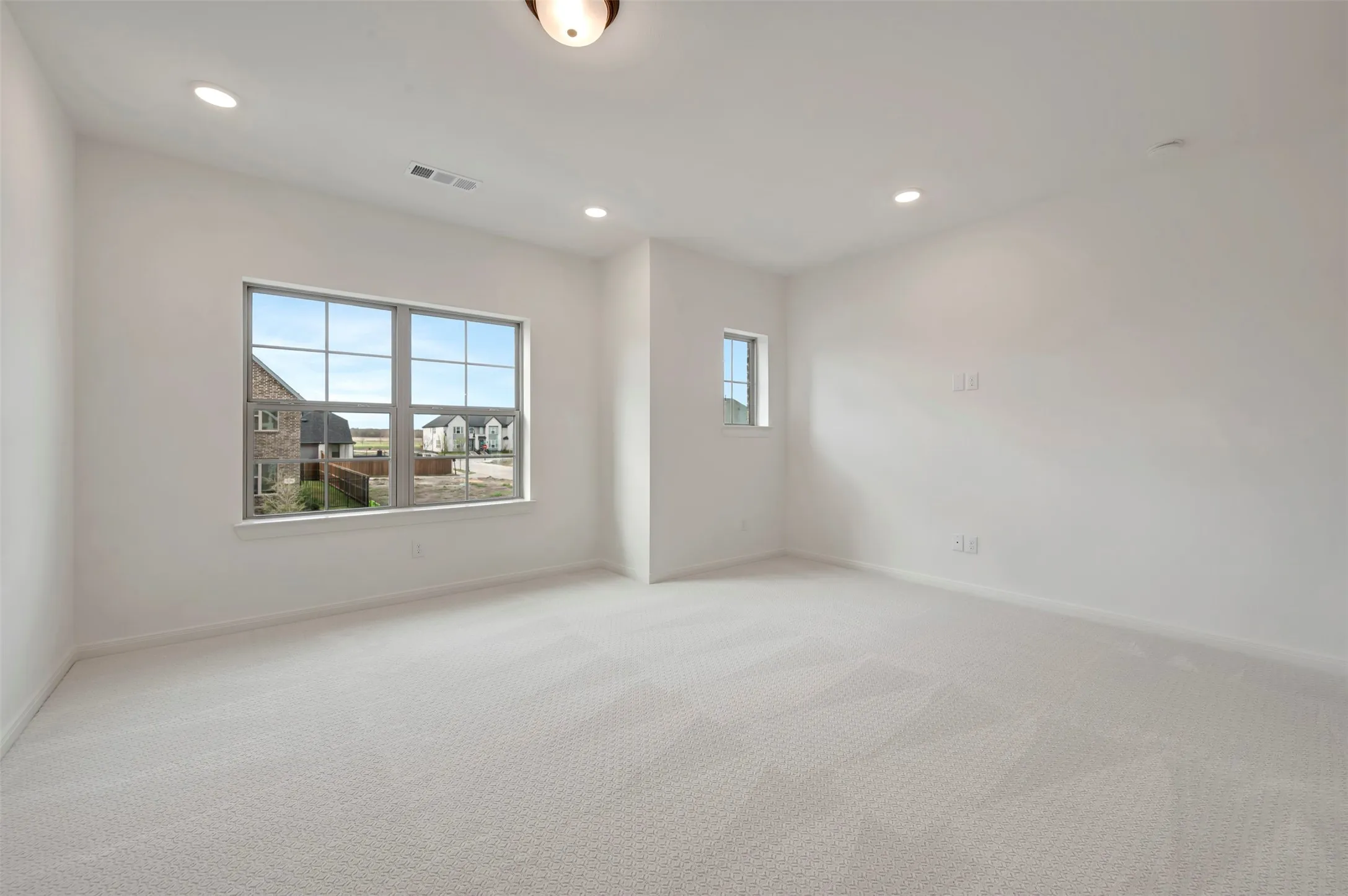 Empty room with recessed lighting and light carpet