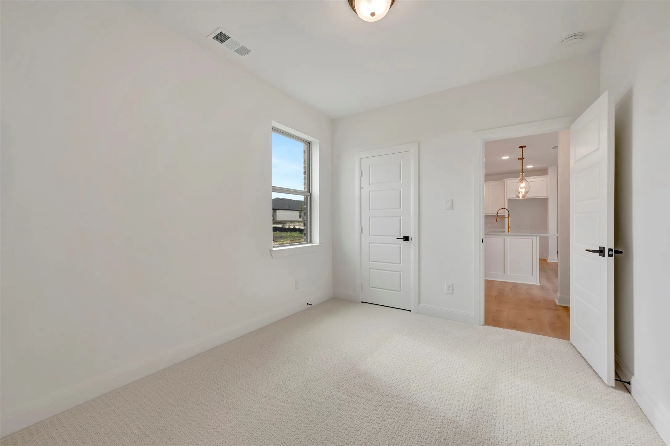 Unfurnished bedroom featuring light colored carpet and baseboards