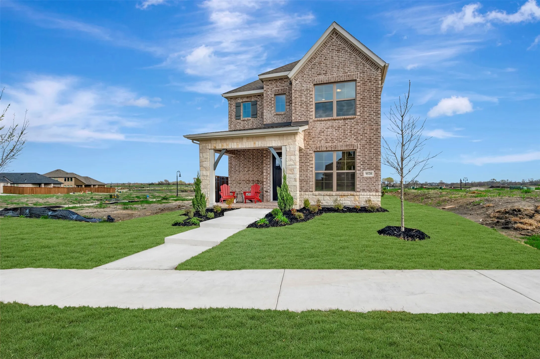 View of front facade featuring brick siding, a porch, and a front lawn
