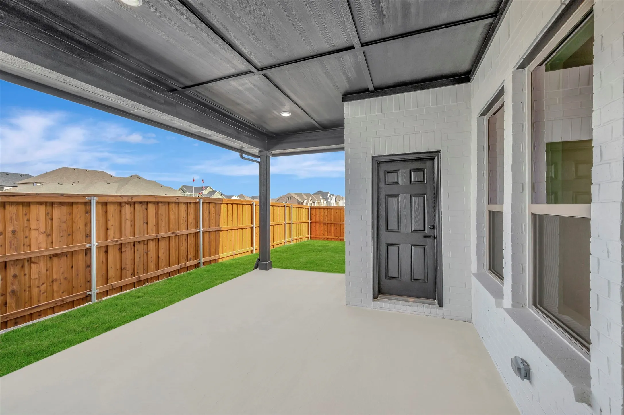 Fenced backyard featuring a patio and a residential view