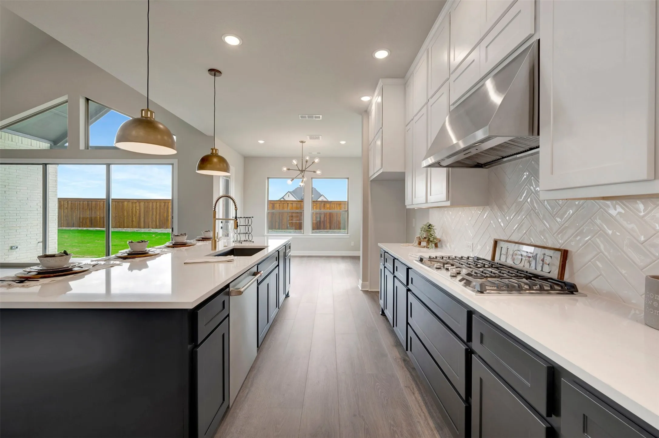 Modern kitchen featuring a large central island with seating, white quartz countertops, and dark lower cabinetry