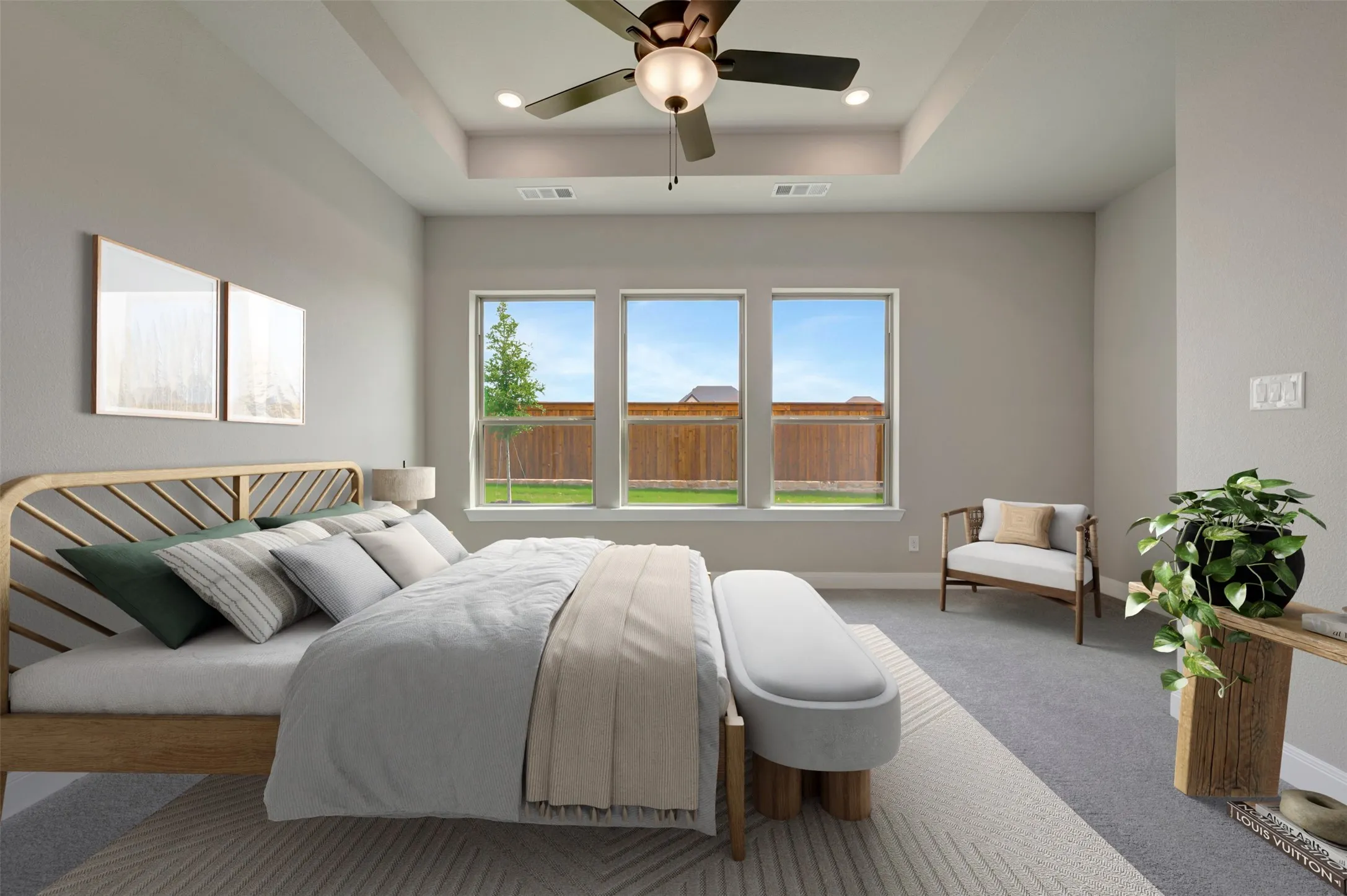 Spacious room featuring a tray ceiling with a ceiling fan, three large windows, and wall-to-wall carpeting