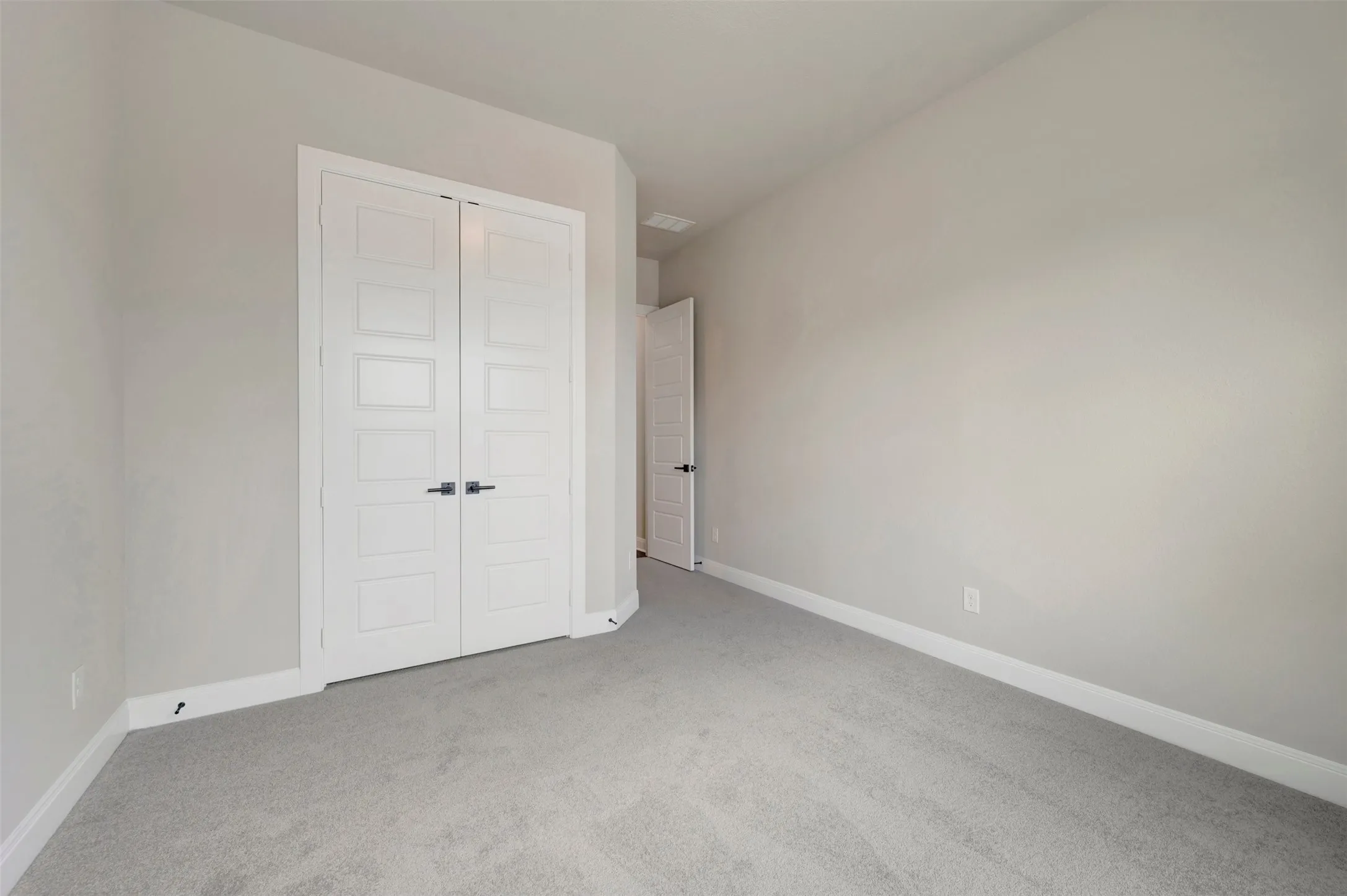 Neutral-toned room featuring light gray carpeting and light gray wall paint