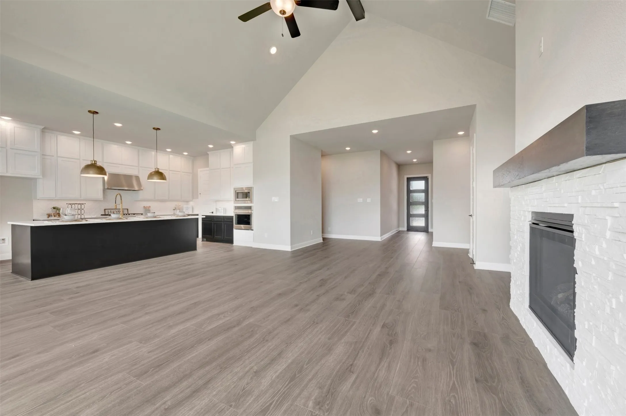 Vaulted ceilings enhance this open concept interior featuring wood-finish​​‌​​​​‌​​‌‌​‌‌​​​‌‌​‌​‌​‌​​​‌​​ flooring