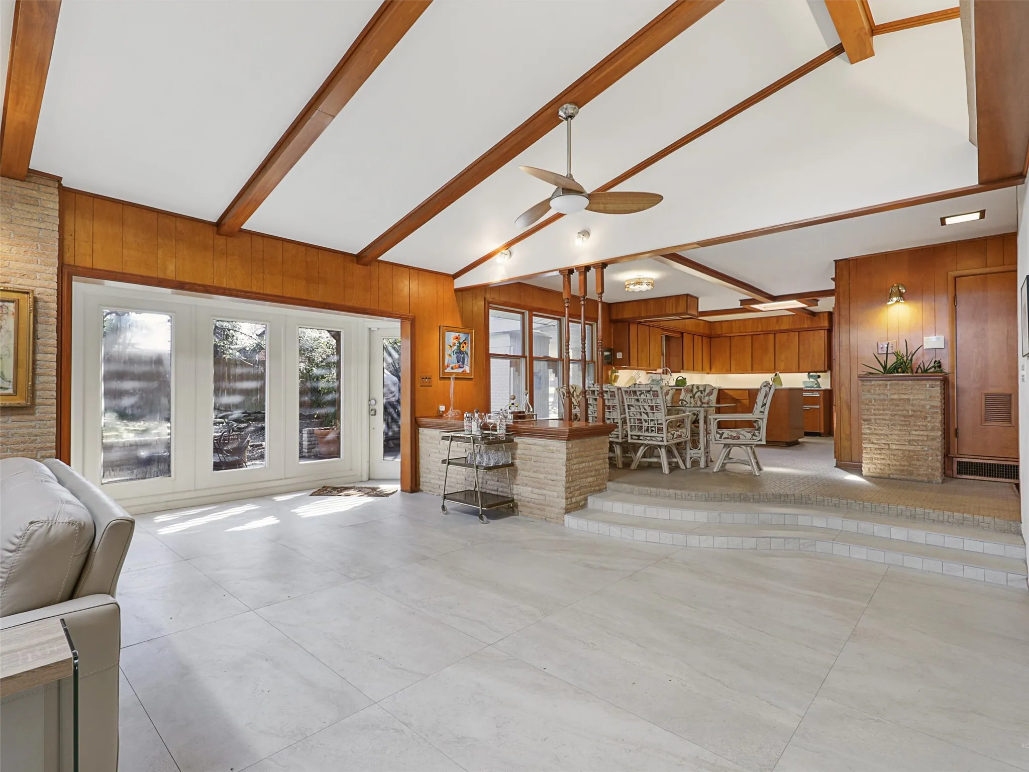 Natural light pours through oversized windows overlooking the garden